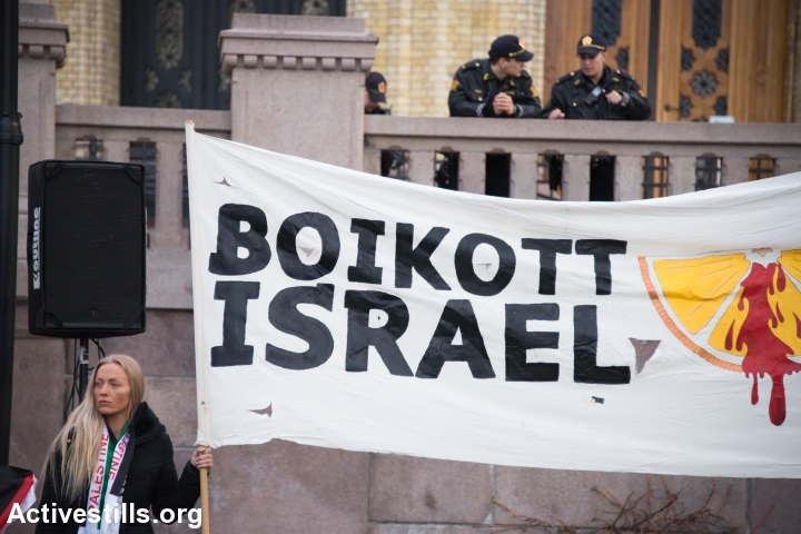 Police watch from above as solidarity activists hold a banner reading “Boycott Israel” during a protest in front of the Norwegian Parliament building, Stortinget, Oslo, March 30, 2015. (photo: Ryan Rodrick Beiler/Activestills.org)