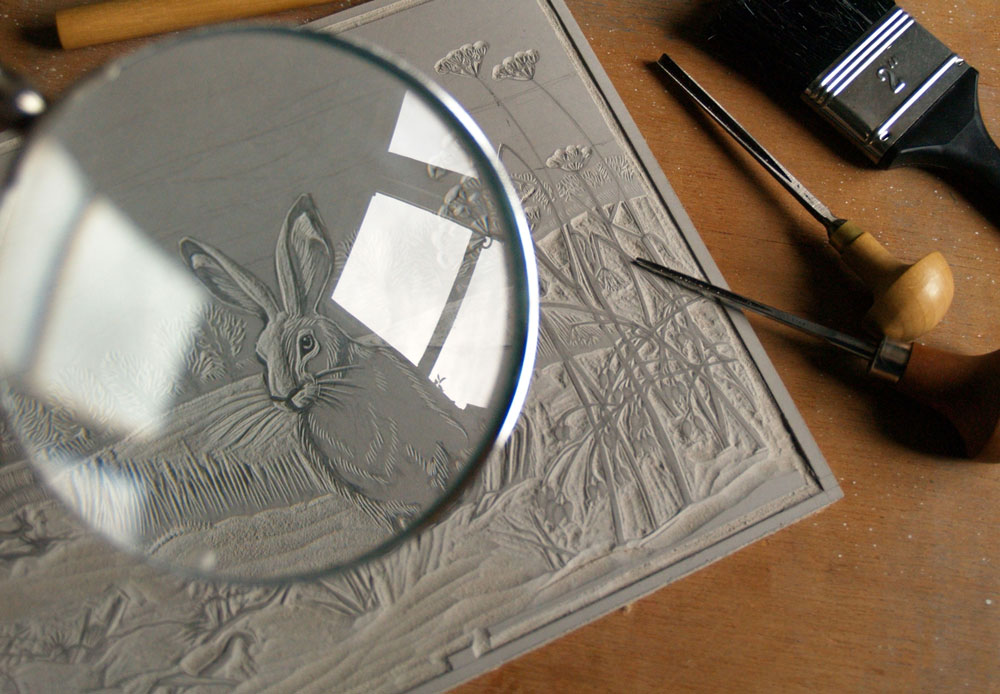 Niki Bowers highlighting the detail of her Winter Hares design carved into linoleum