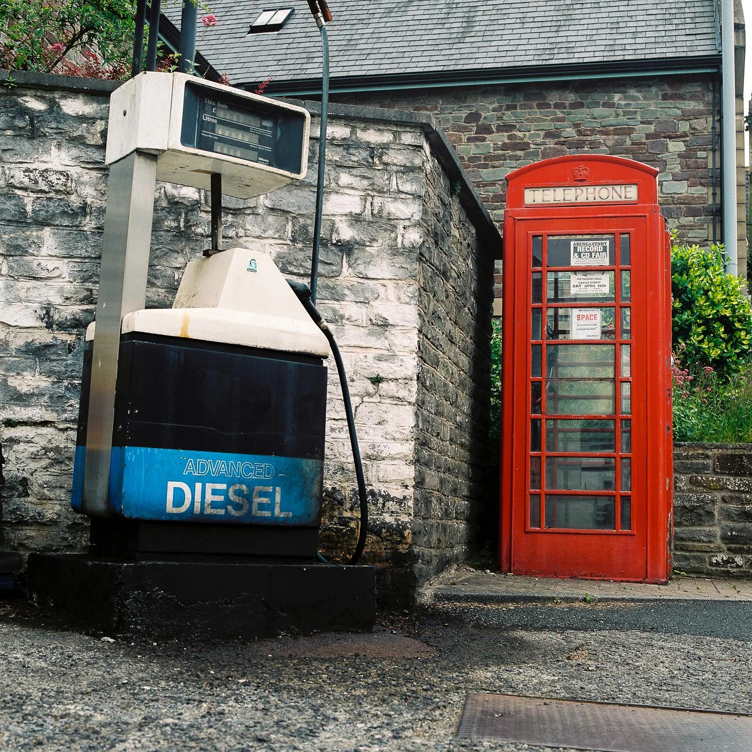 An old diesel pump and a phone box next to each other, a typical scene in rural British town