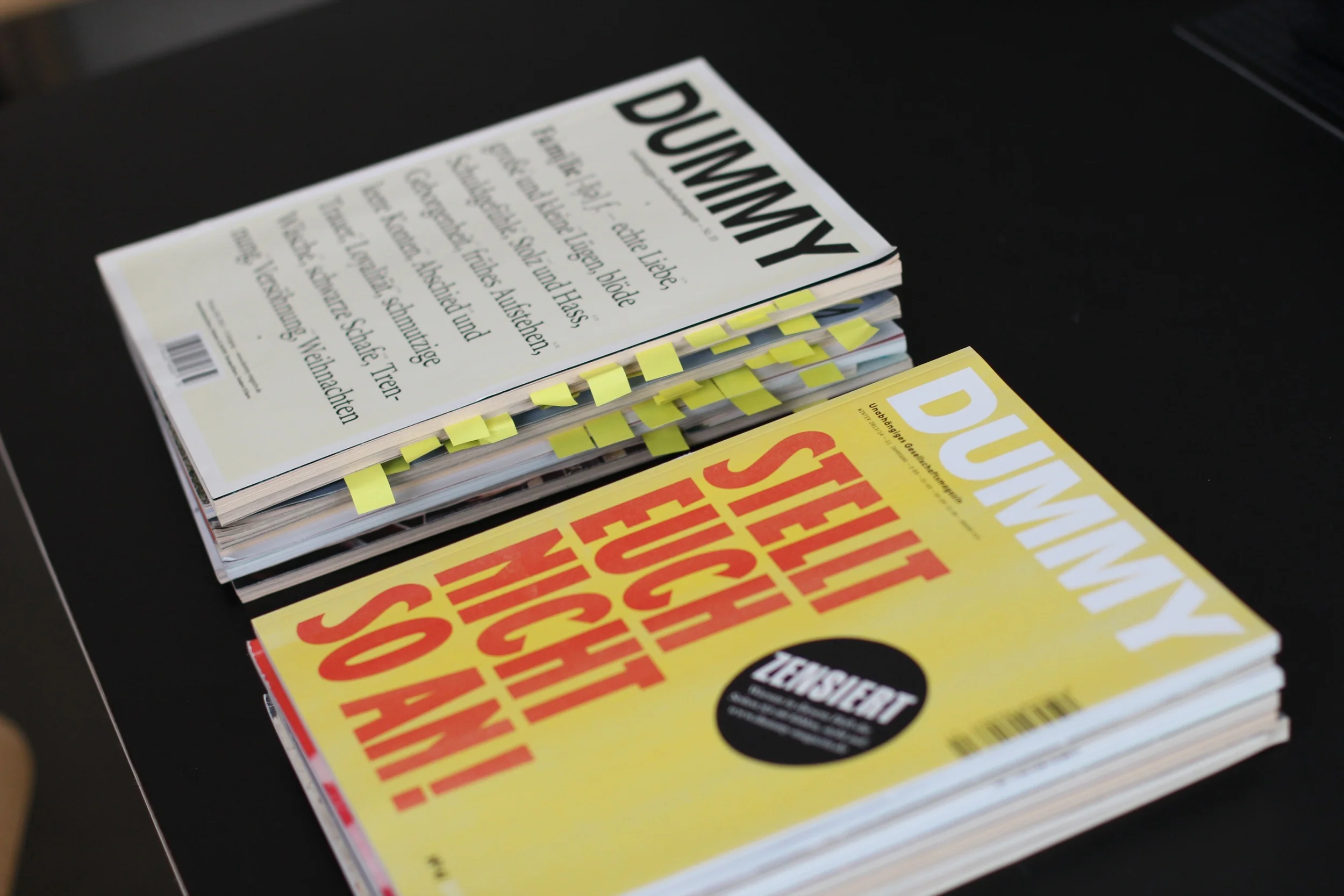 Zwei Stapel Ausgaben des ganz hervorragenden DUMMY-Magazins. In einem Stapel waren in jedem Heft ausgewählte Artikel mit Post-is markiert, im anderen nicht.