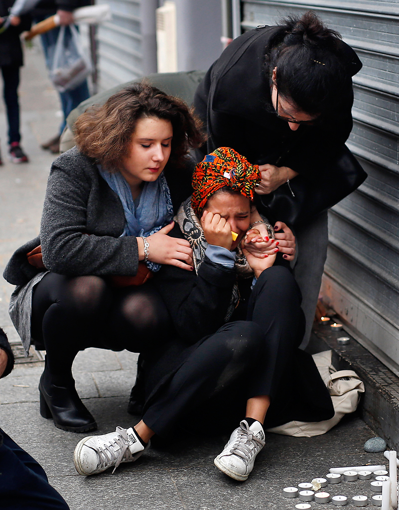  A woman is comforted by others outside the Carillon cafe and the Petit Cambodge restaurant in Paris, Saturday Nov. 14, 2015, a day after over 120 people were killed in a series of attacks in Paris.  Photo by Jerome Delay/AP 