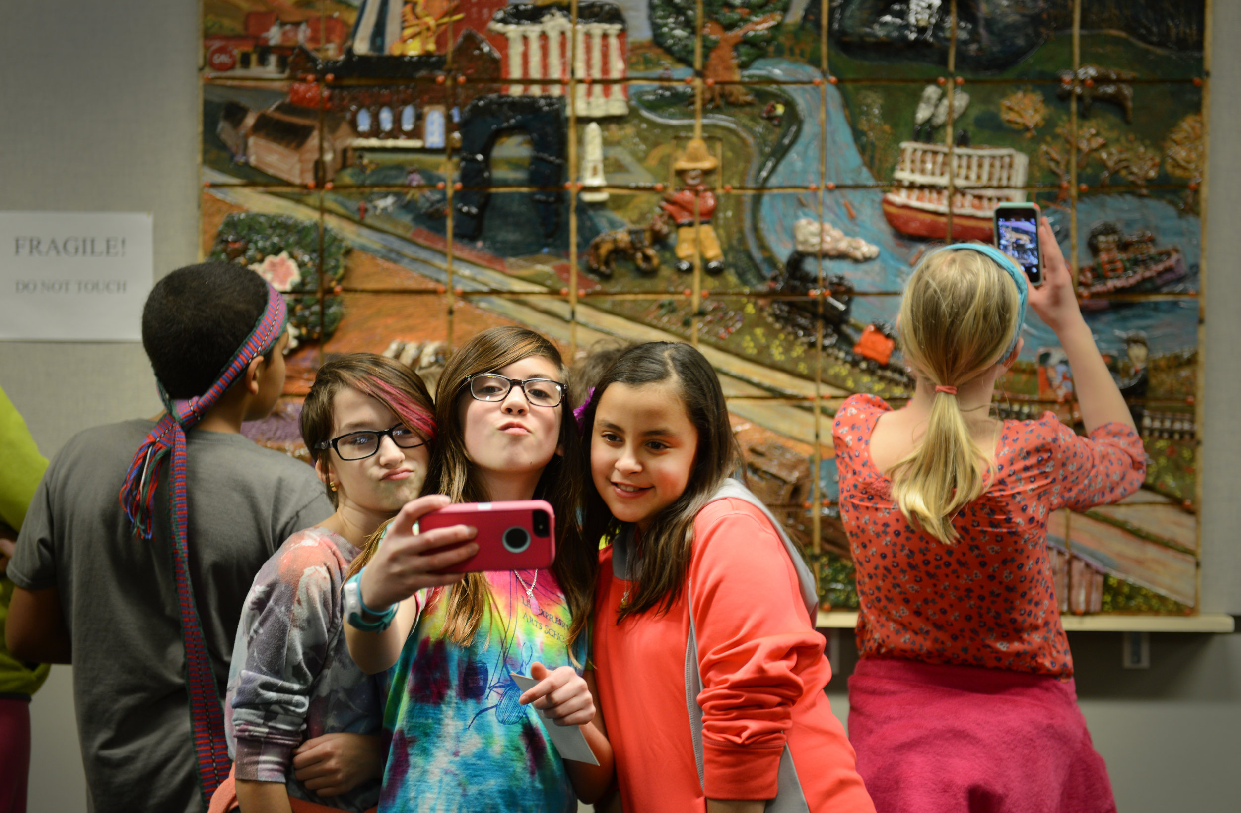 From left, Lee Expressive Arts Elementary students Devin Hall, 10, Ellie Bacon, 11, and Keya Beamer, 10, take a selfie in front of the mural they helped create on Tuesday, March 3, 2015, in Columbia, MO. The fifth grade class at the elementary school made the mural for the State Historical Society.