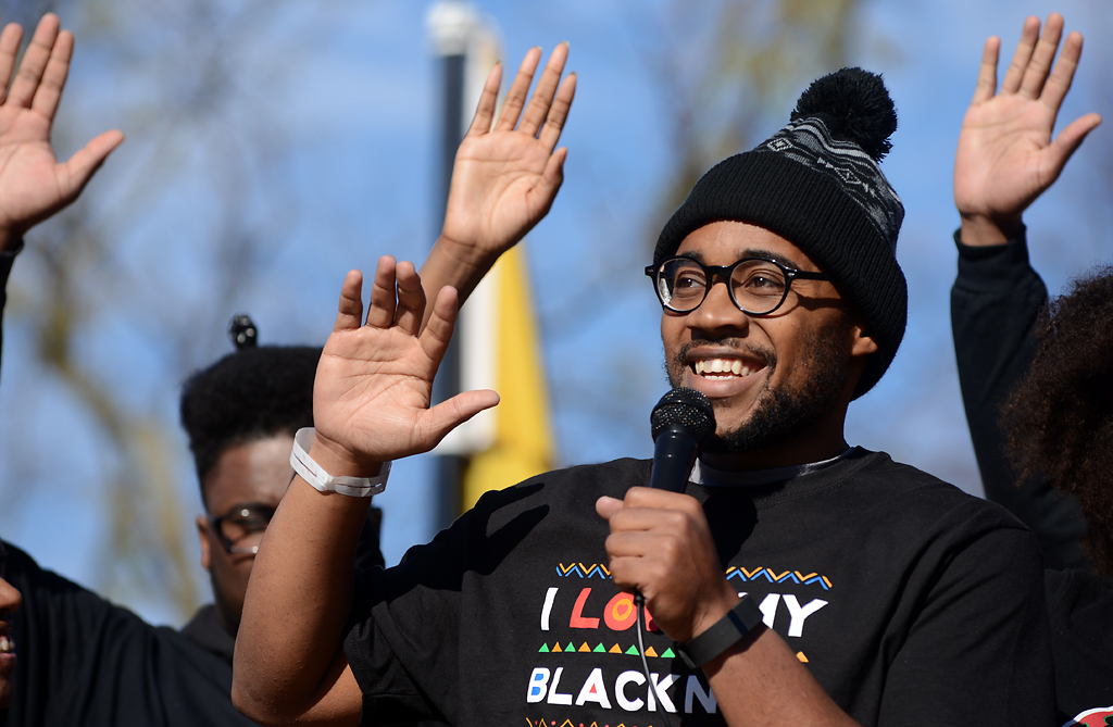  Jonathan Butler raises his hand asking everyone to repeat, "I am a revolutionary," during a press conference held by Concerned Student 1950 at Traditions Plaza on Monday, Nov. 9, 2015. Butler had been on a hunger strike for seven days to protest Tim