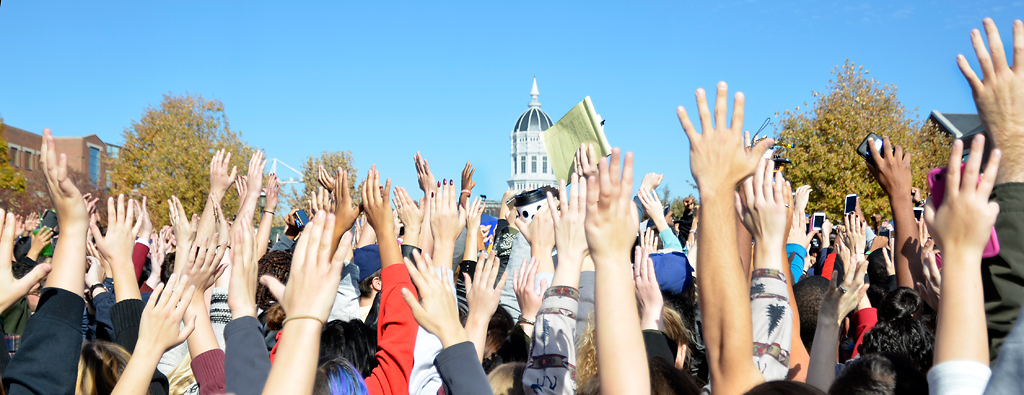  Concerned Student 1950 supporters throw their hands up to block media from taking photos on Monday, Nov. 9, 2015. The media was unwelcome inside the circle of supporters and were yelling, "get the media out!"  Photo by Halee Rock/Missourian 