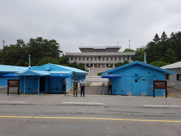 The JSA tour group was allowed to take a photo here, at the site of the 38th parallel, where South Korean guards stand at attention all day, half behind the blue conference houses and half exposed to the North Korean side, in case an attack occurs. The building on the opposite side belongs to North Korea. The man standing on the steps of the building is a North Korean solider and, allegedly, behind those windows are plenty other soldiers watching us take photos of them. 