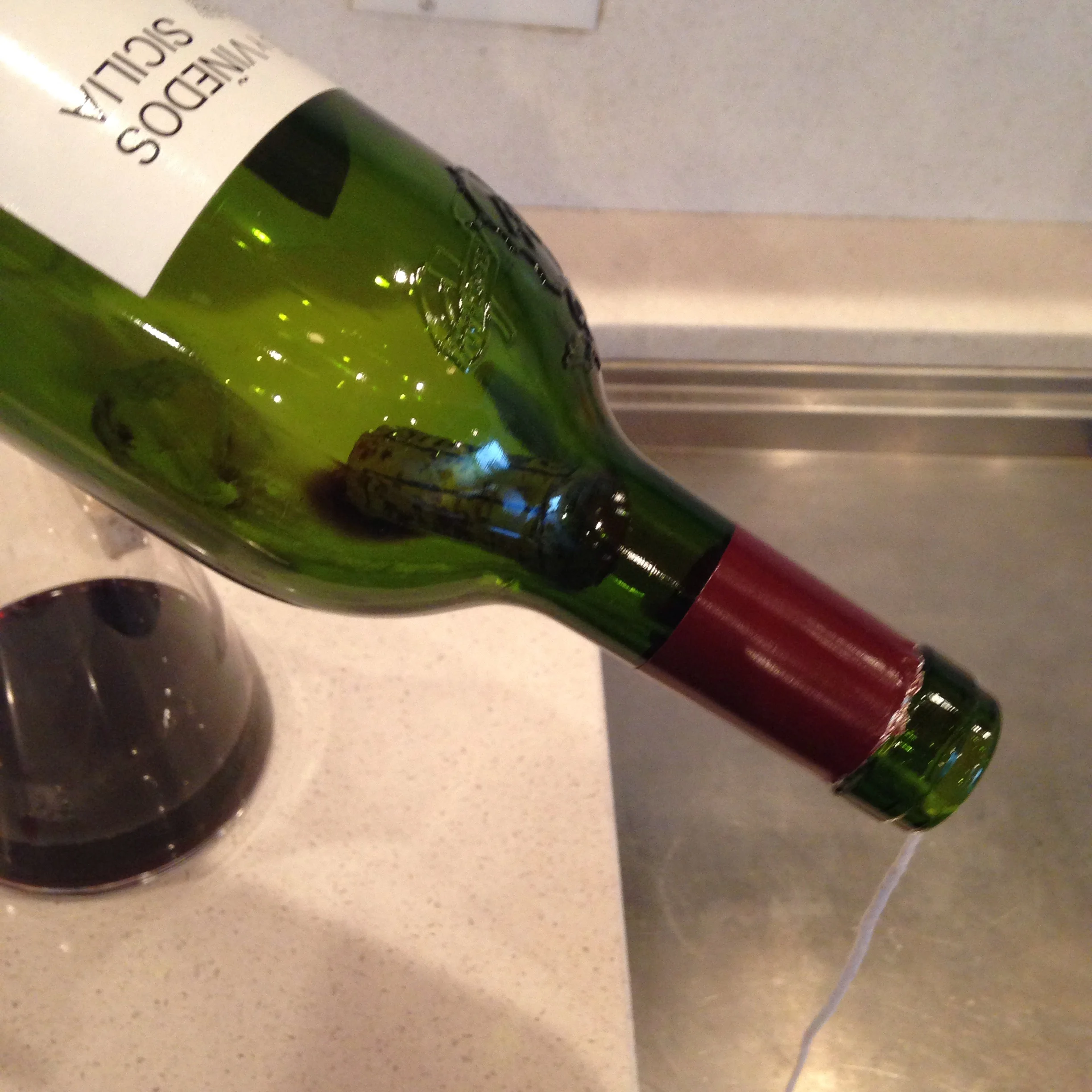 Step 5: Tilt the bottle in order to get the cork as close to the neck as possible. The knot should be behind the cork.