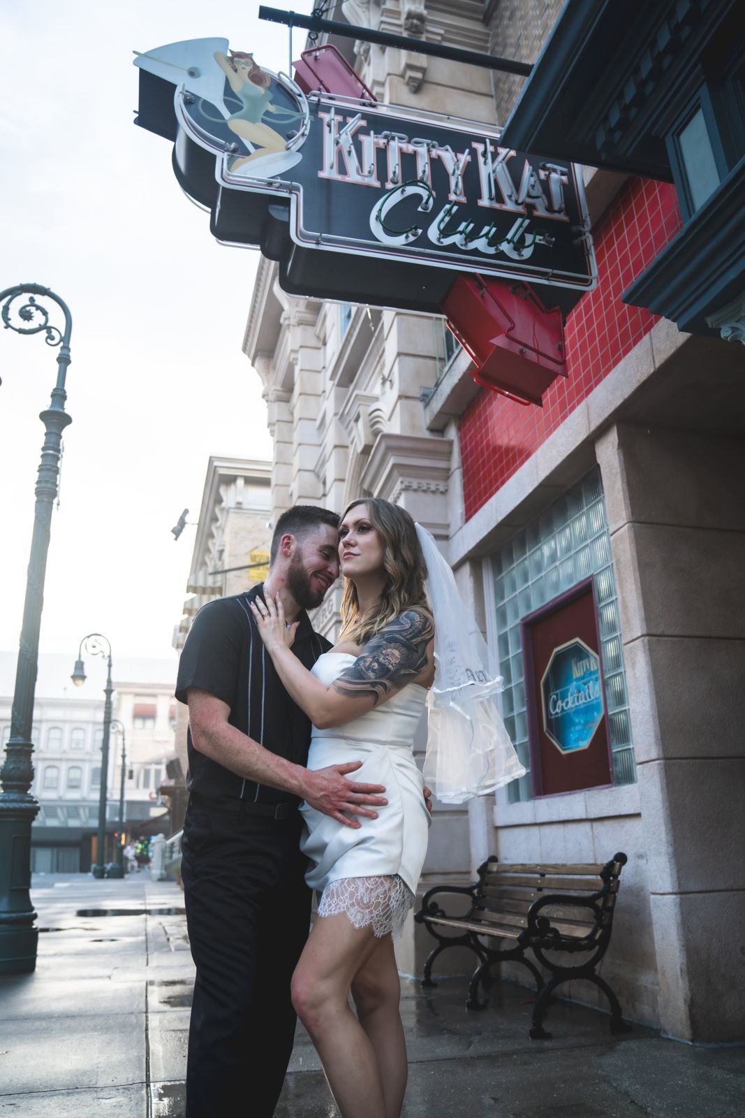 Couple embracing under the Kitty Kat Club neon sign at Universal Studios Florida