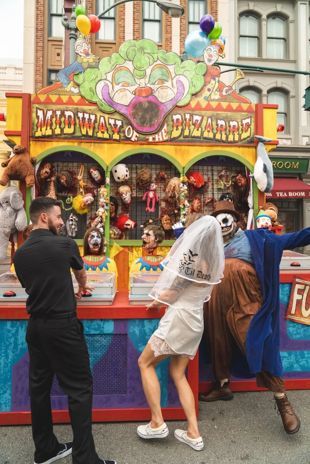 Bride and groom playing at the Midway of the Bizarre with a scare actor, Halloween Horror Nights 35