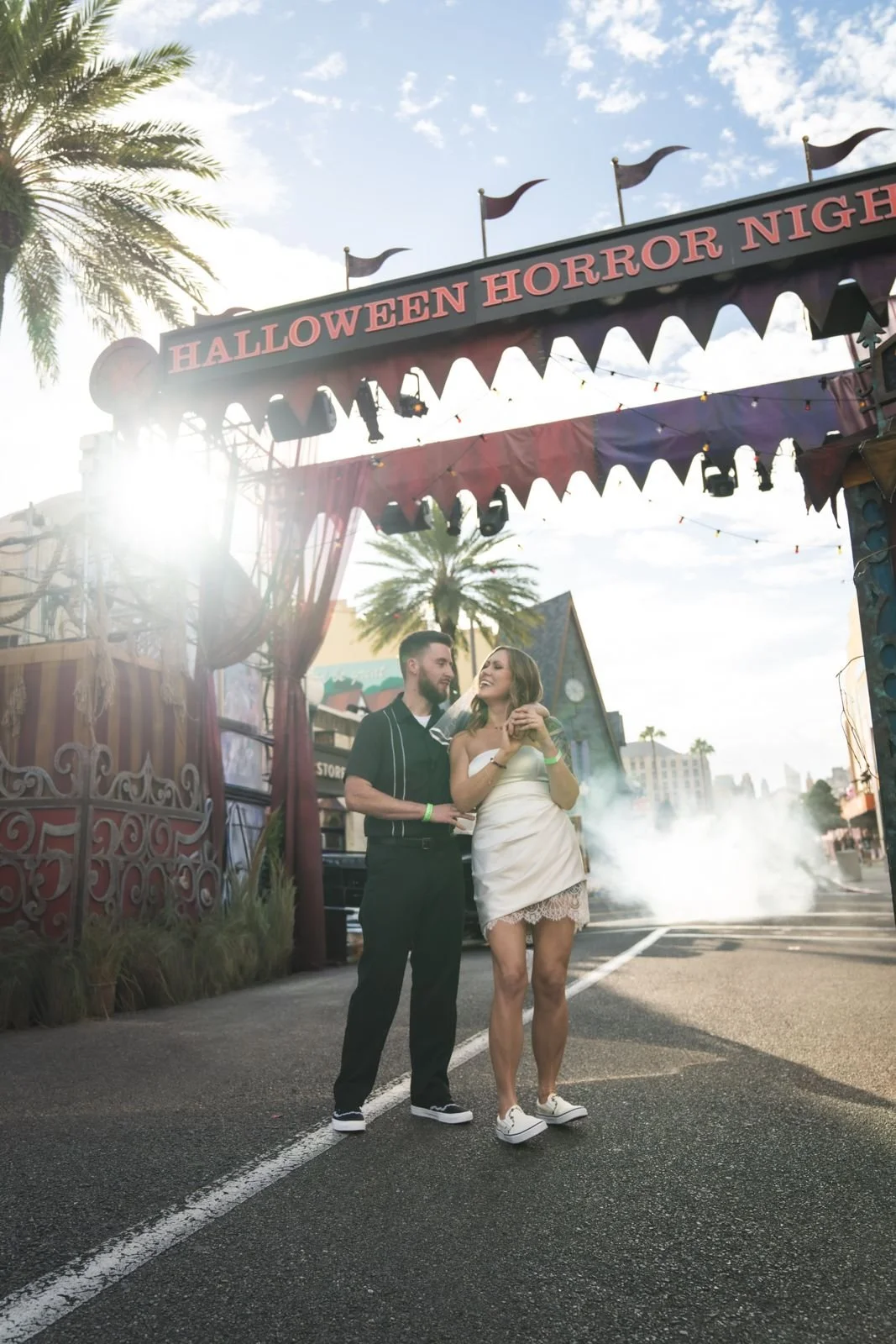 Couple laughing under the Halloween Horror Nights arch with fog at Universal Orlando