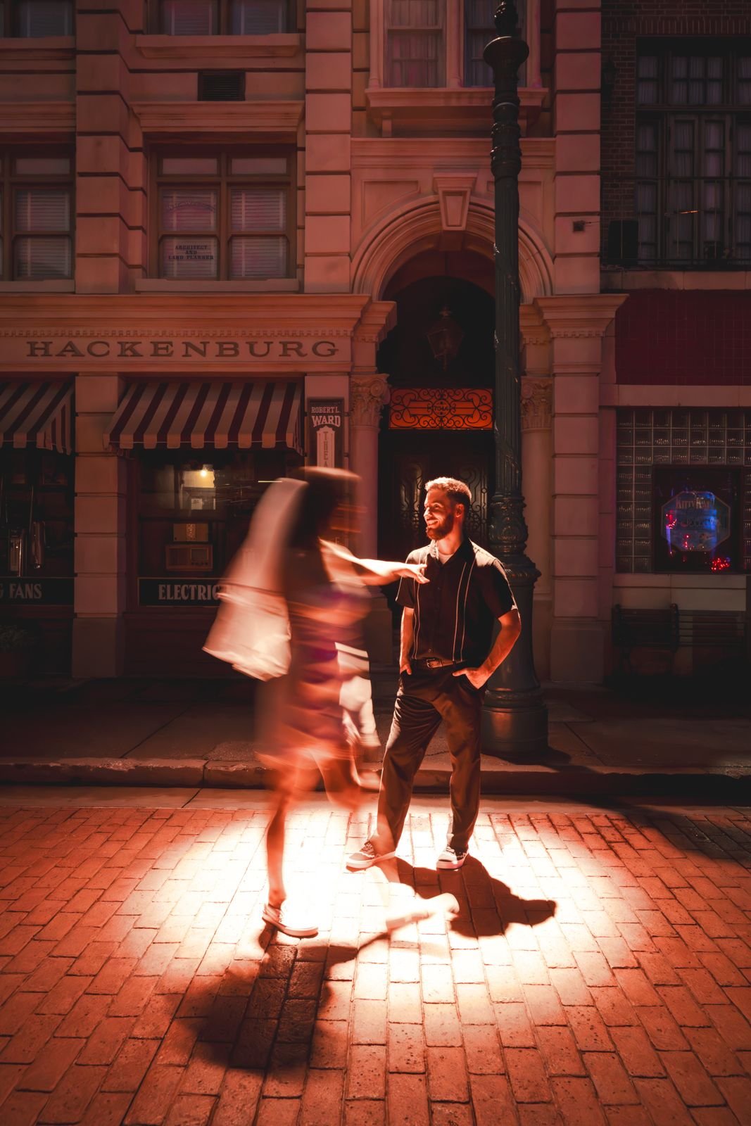 Bride spinning past the groom under a warm streetlight at Universal Studios Florida