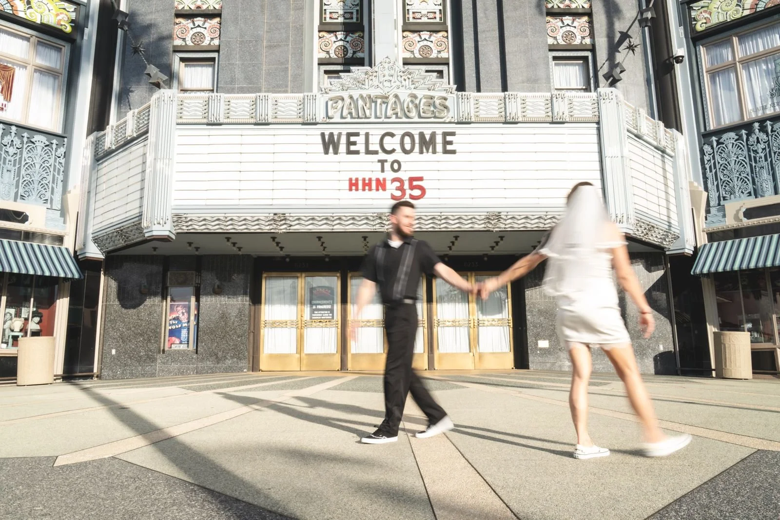 Couple walking hand in hand past the Welcome to HHN 35 marquee at Universal Orlando