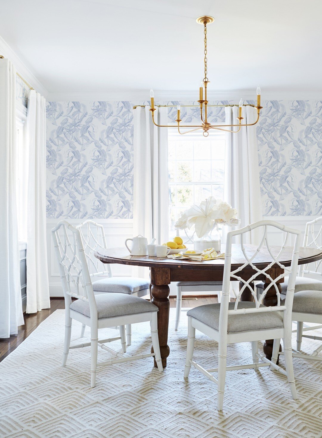 I love the mix in this Dining Room. What designers know is how to layer all the patterns and finishes to create an inviting space that makes you want to linger longer. Painted chairs with the wood table, bright brass chandelier, and of course Stay Wi