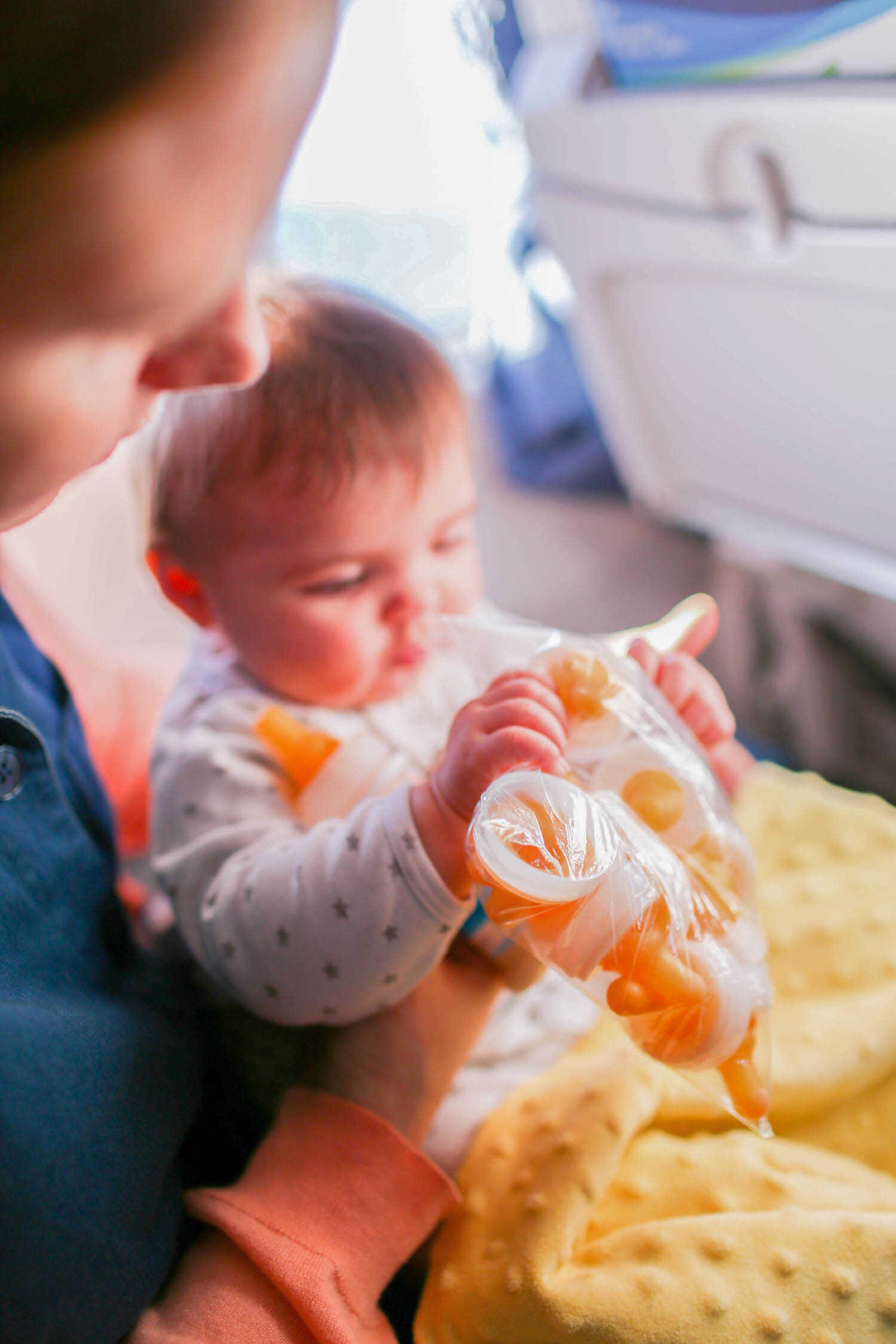 Baby Scout holding her Ready-to-Feed sterilized nipples on the airplane.