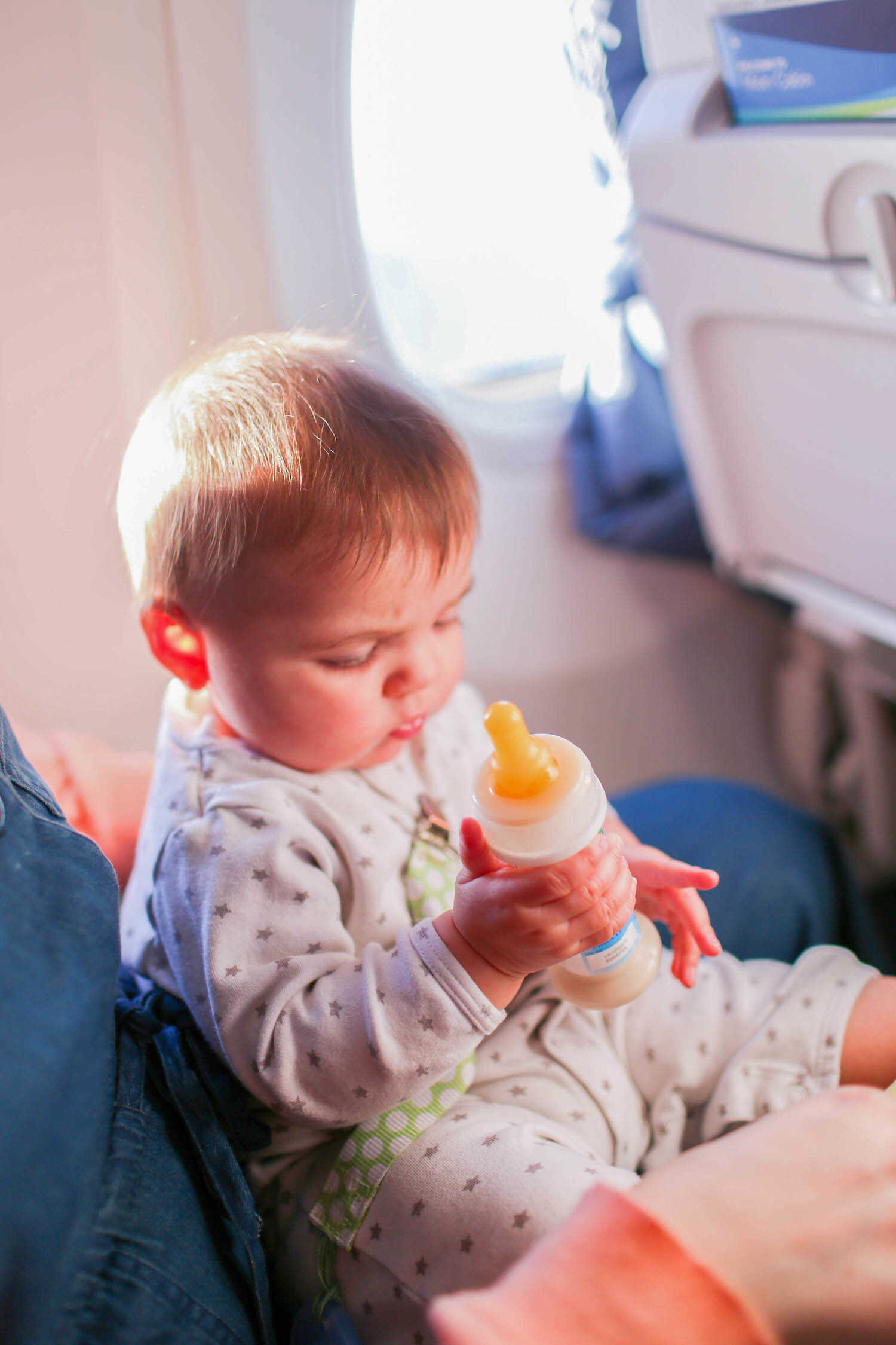 Baby Scout holding her Ready-to-Feed formula bottle on the airplane.