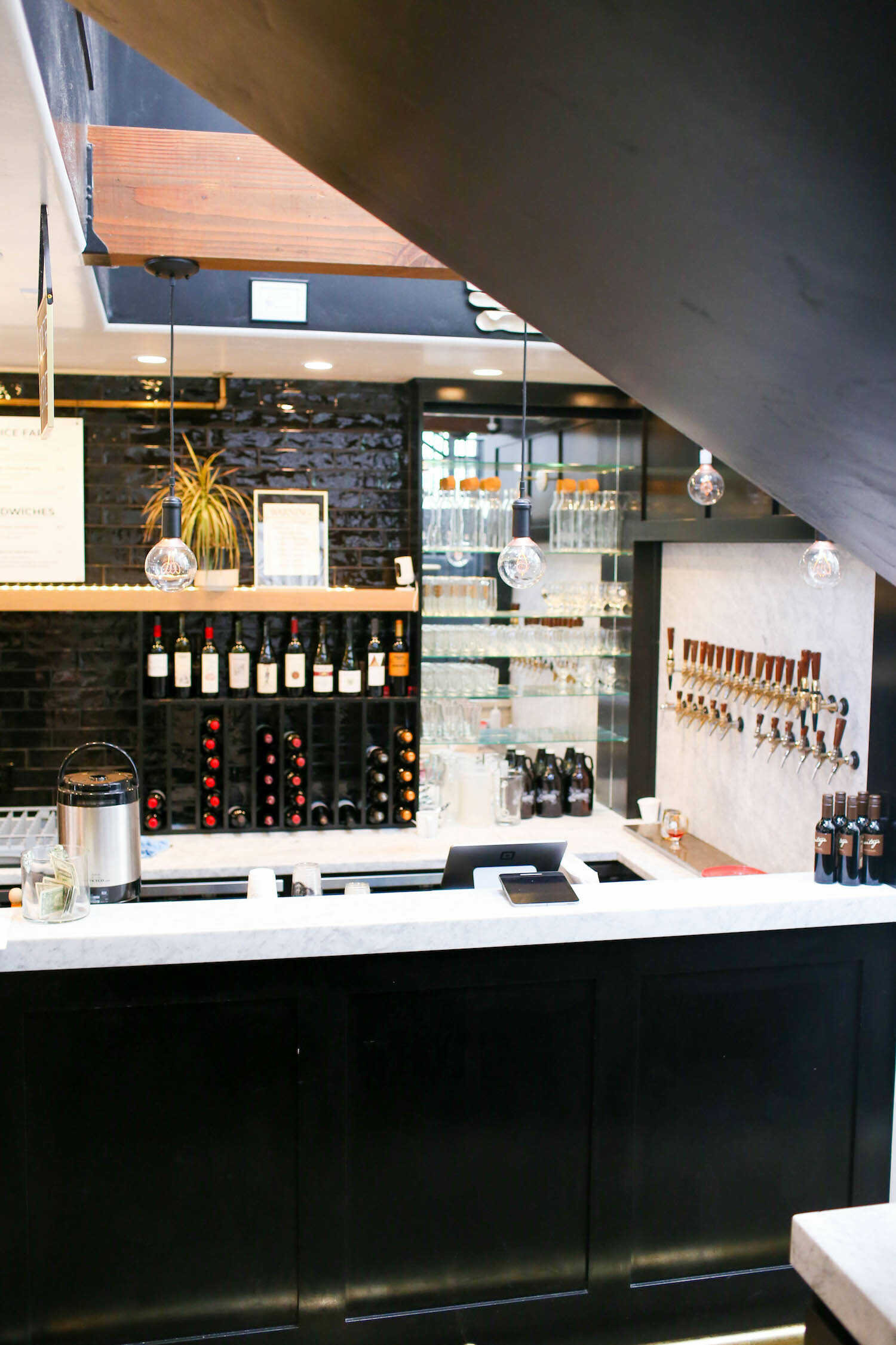 Barista brews and wine backbar inside The Pour Choice Coffee Shop in Auburn.