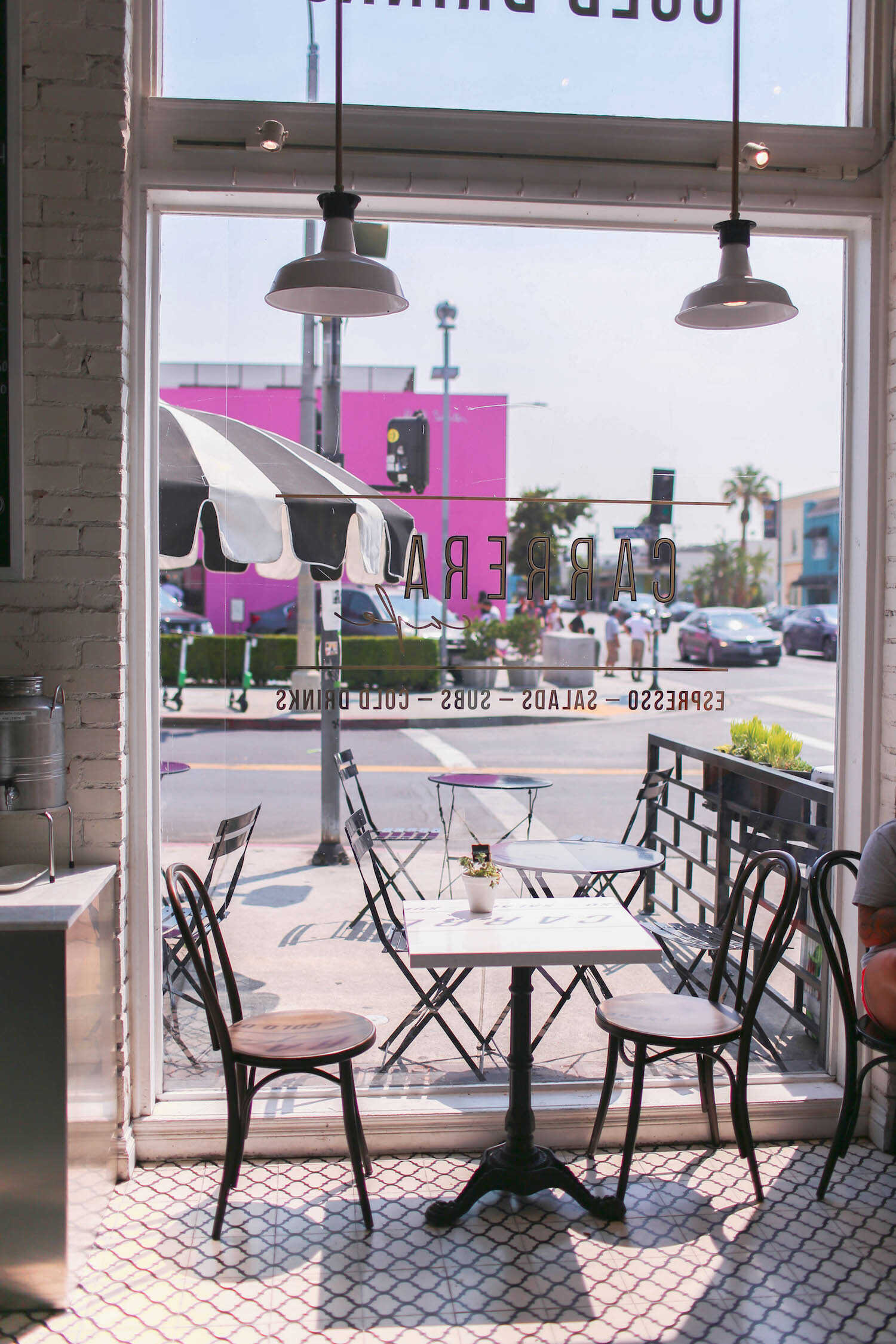 Cafe interiors and view of Pink Wall outside the window at Carrera Cafe in West Hollywood.