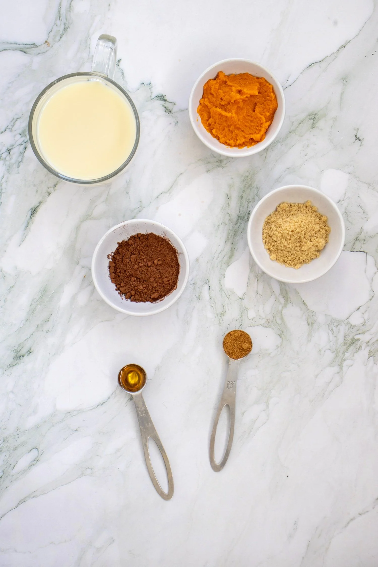 Pumpkin Spice Hot Chocolate ingredients including pumpkin puree, milk, cocoa powder, brown sugar, vanilla, and pumpkin pie spice.