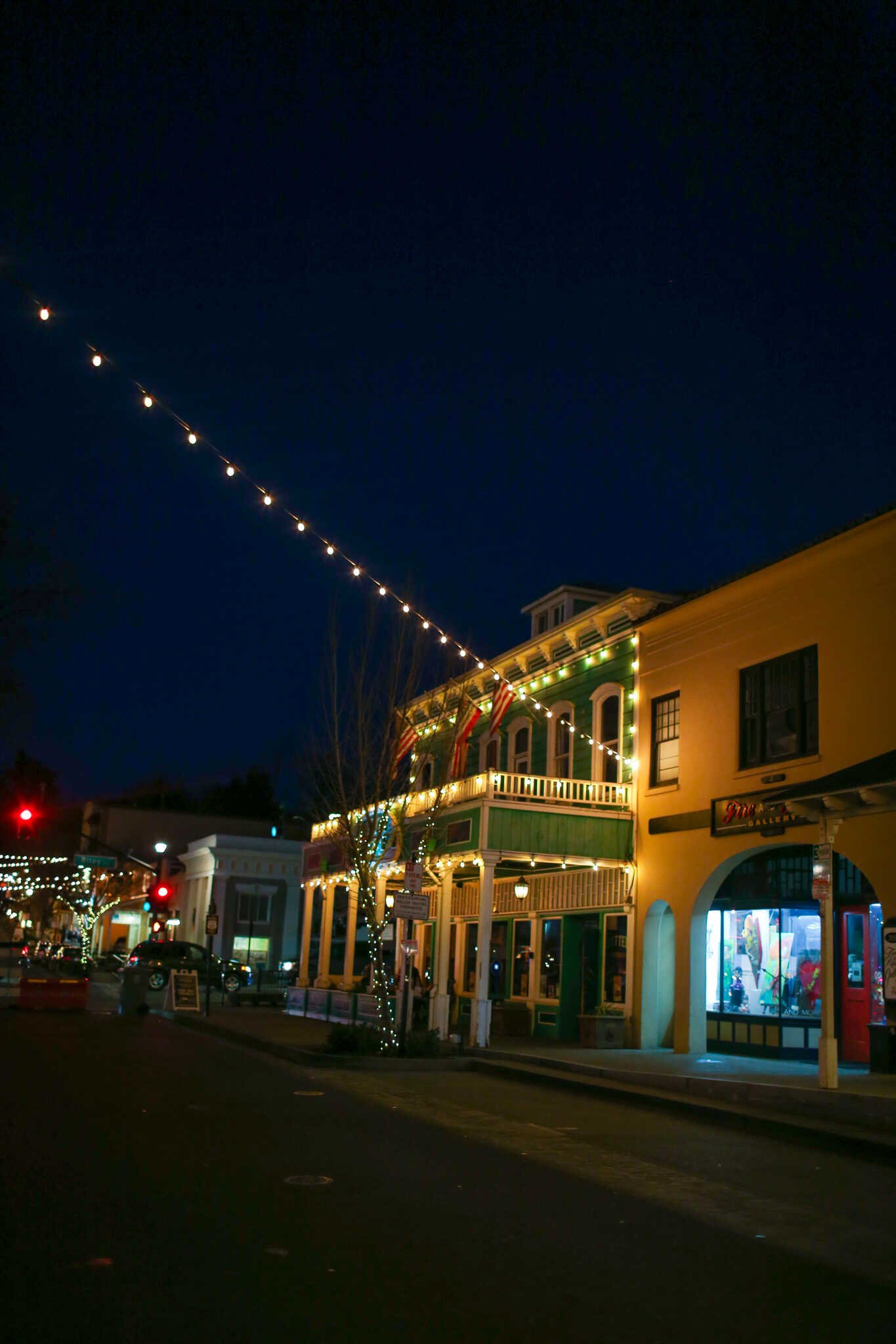 Family Travel Guide to Folsom California - Twinkle lights and the historic Folsom Hotel at night on Sutter St in the Folsom Historic District.