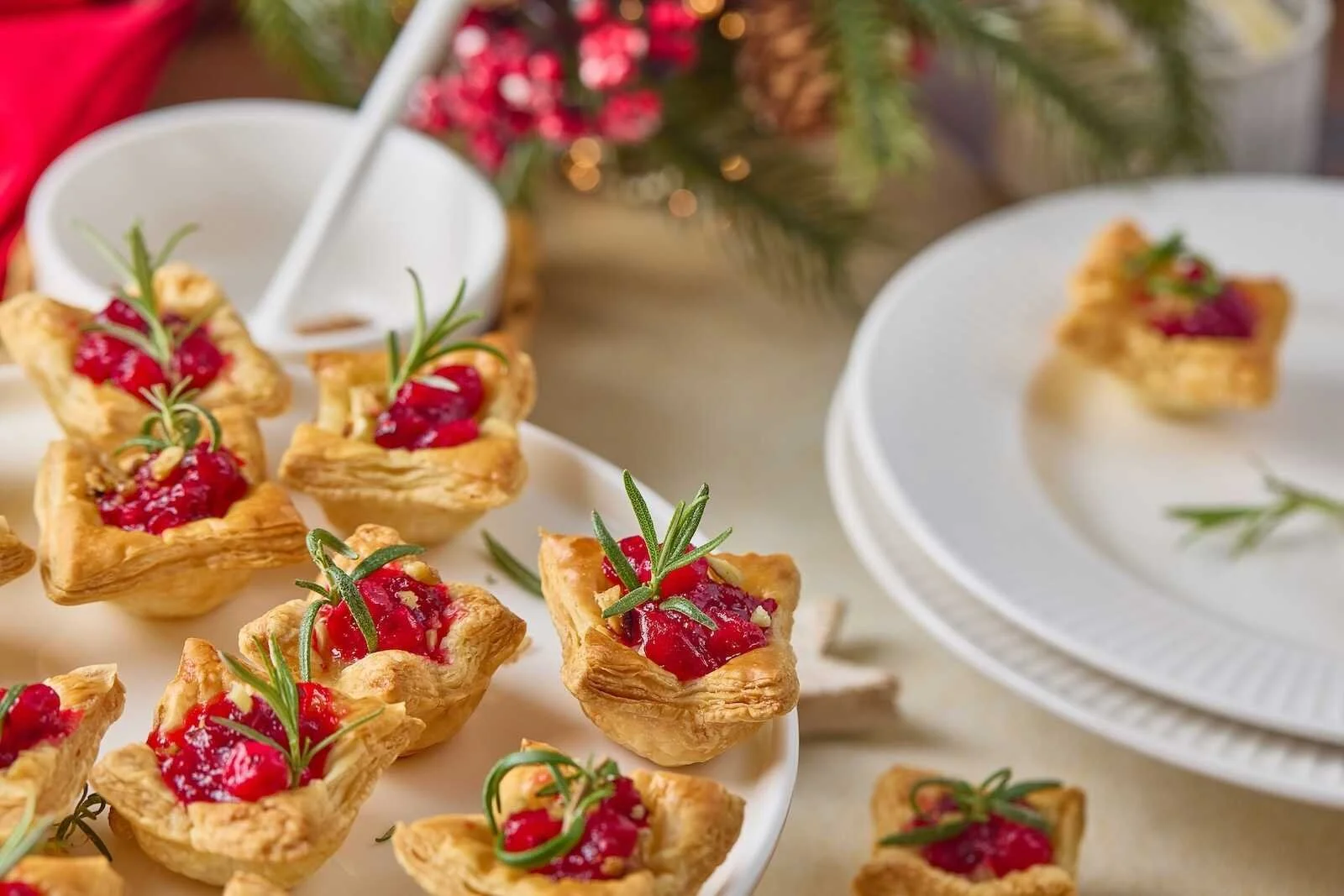 Holiday Heaven Bites made with flaky puff pastry, creamy Brie cheese, homemade cranberry topping, and fresh rosemary, served as an easy holiday appetizer.