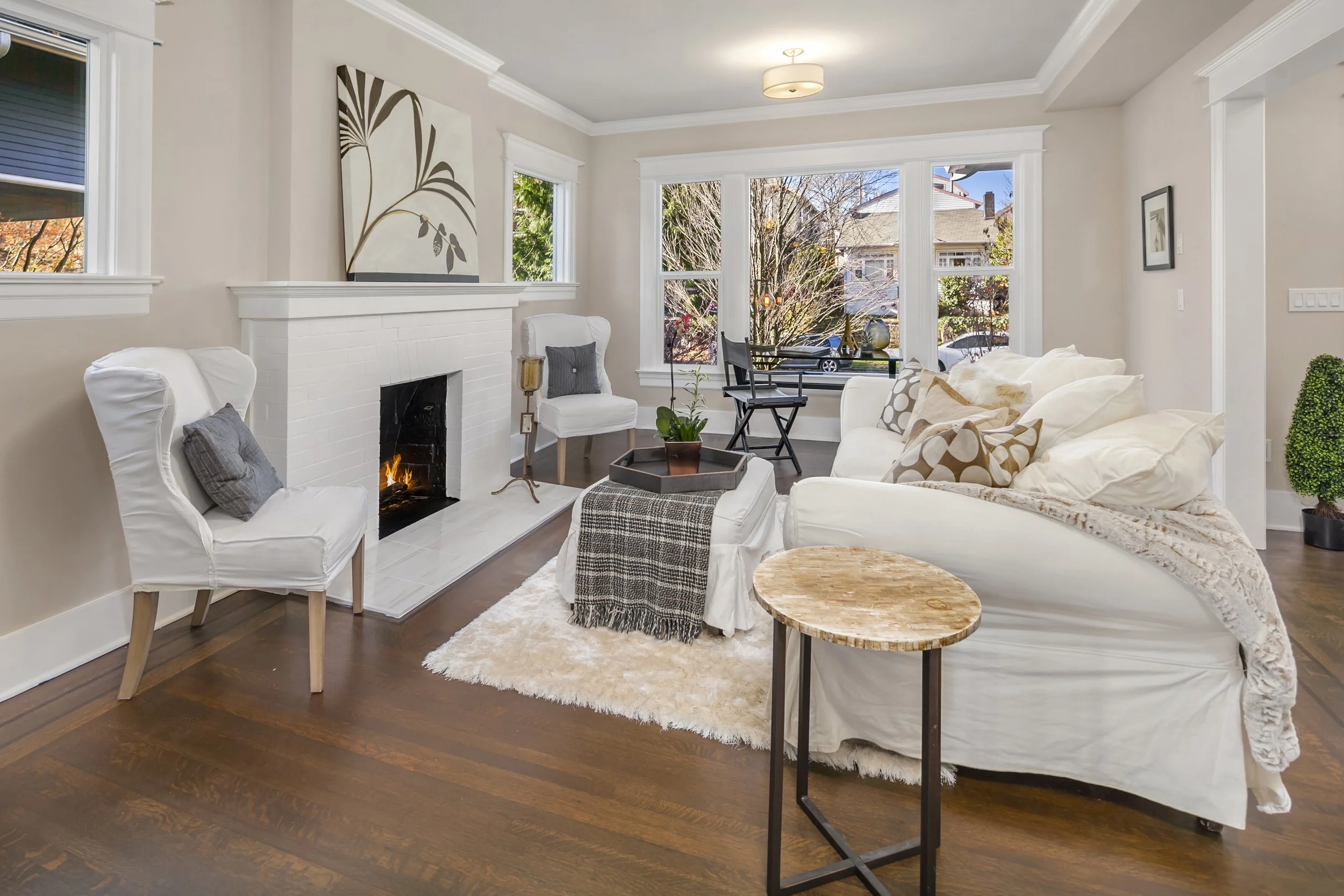 Living room/fireplace — after: Renovated living room with painted brick fireplace, gas insert, and new mantel