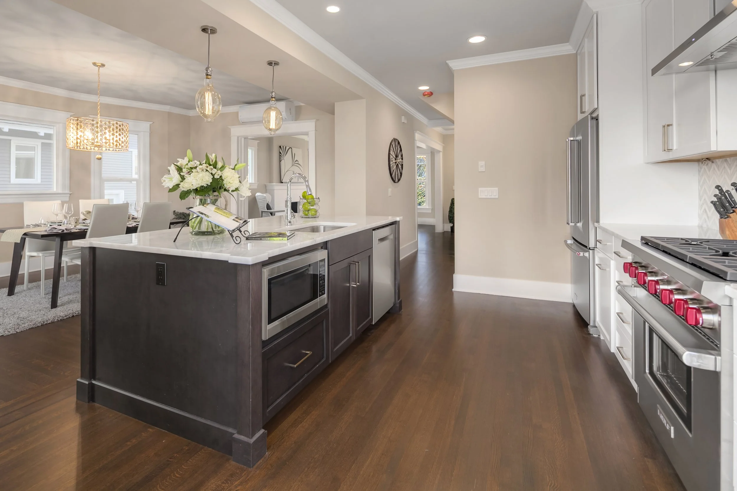 Kitchen/dining — after: Renovated kitchen opened to dining room with new island and restored hardwood flooring