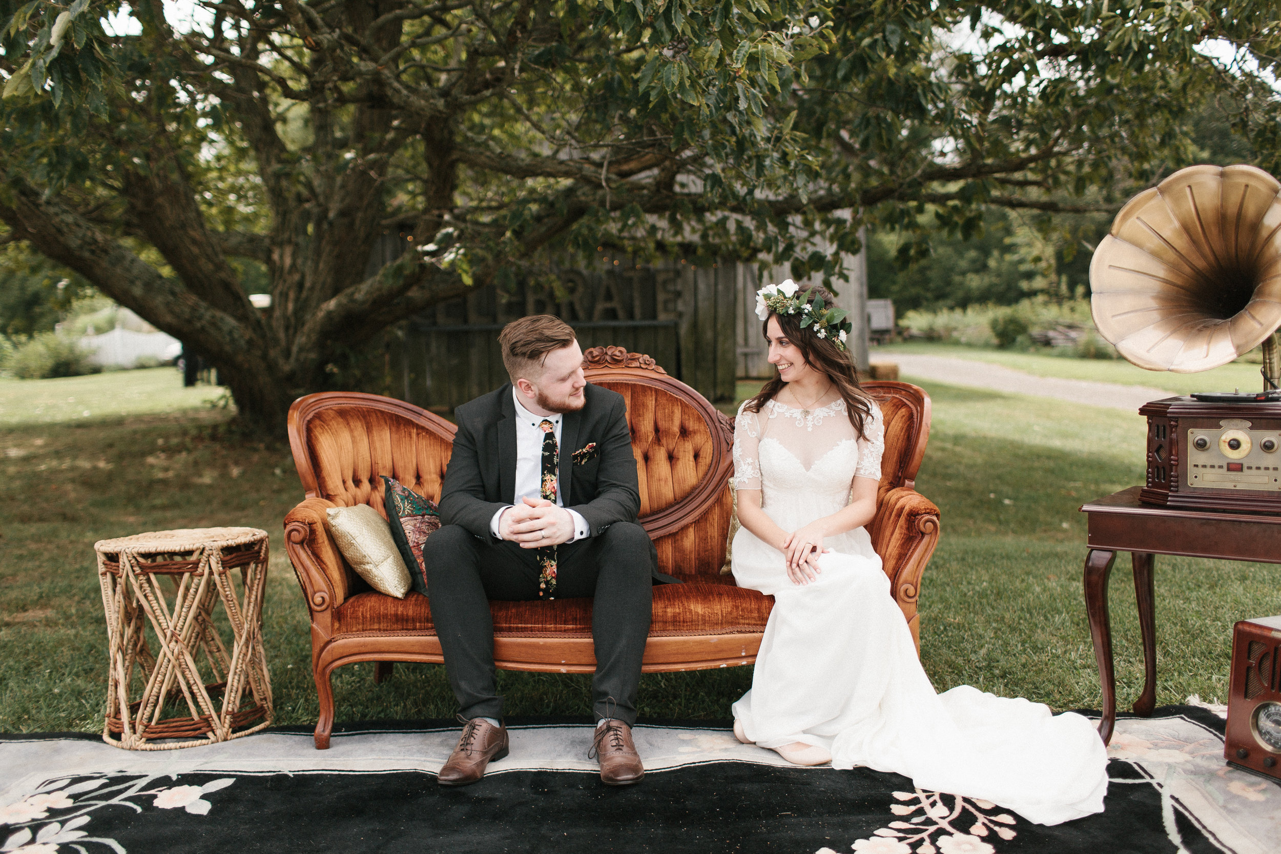  Groom and bride sit on couch for unique wedding photo. 