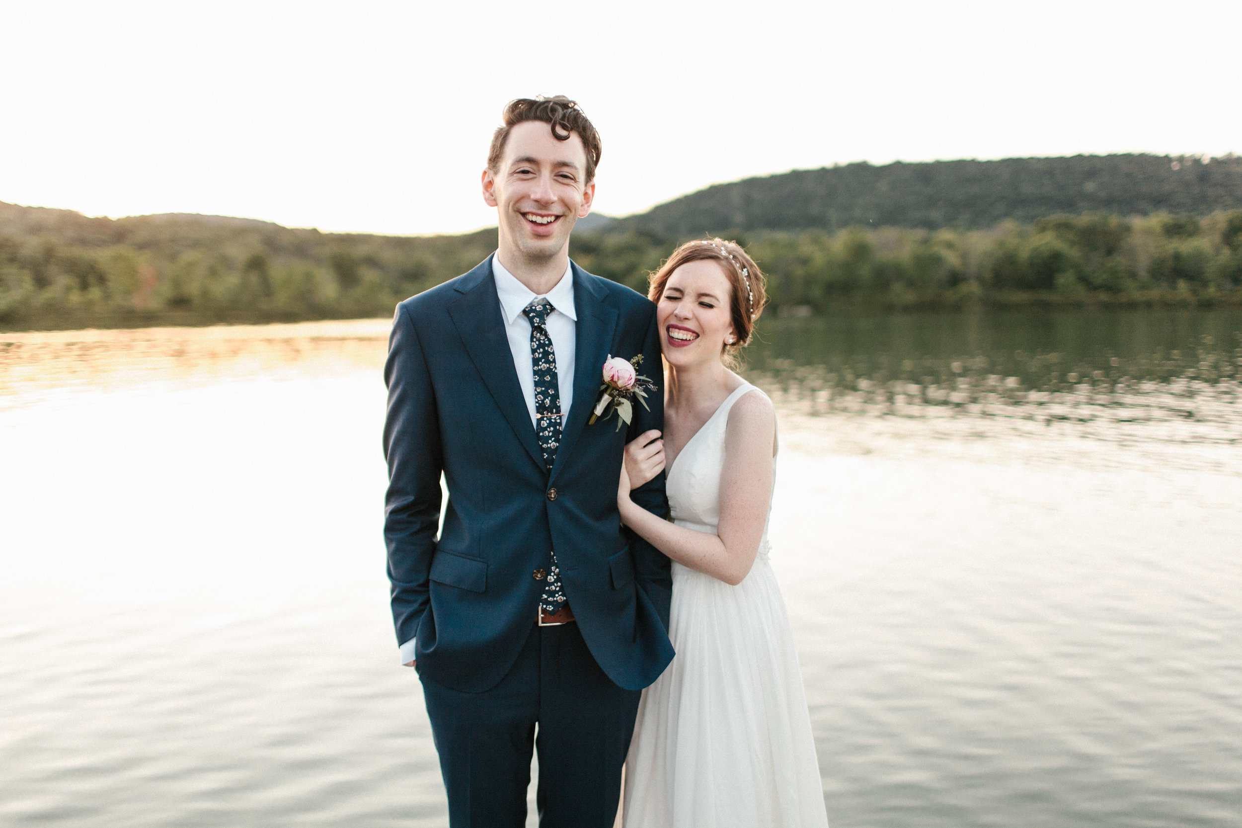  Bride and groom stand on dock at Bald Eagle State Park. 