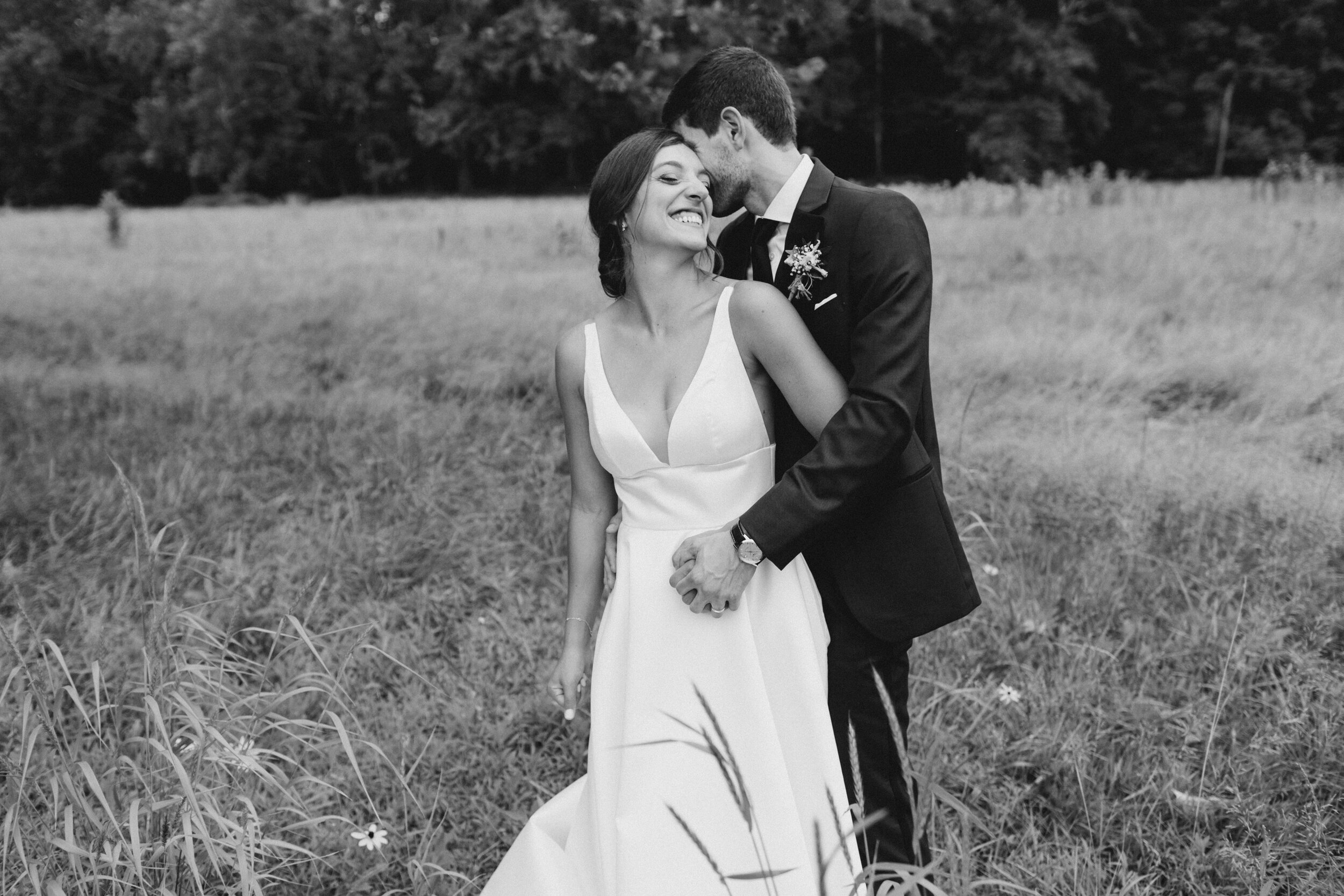  Bride and groom hug in field at Natirar. 