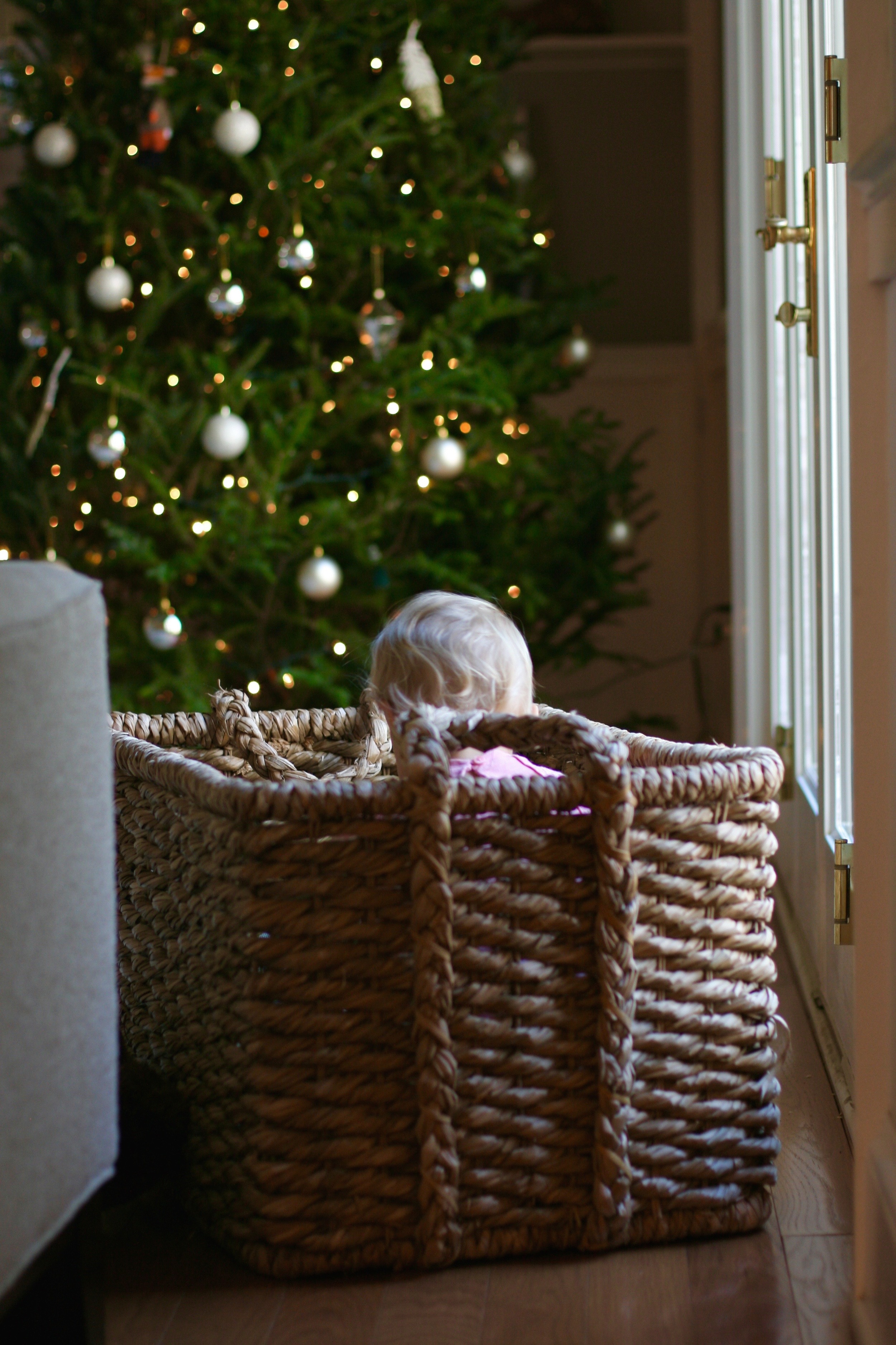 Because who doesn't want to dive into a basket of toys while staring at the glittery Christmas tree? Smart little lady.