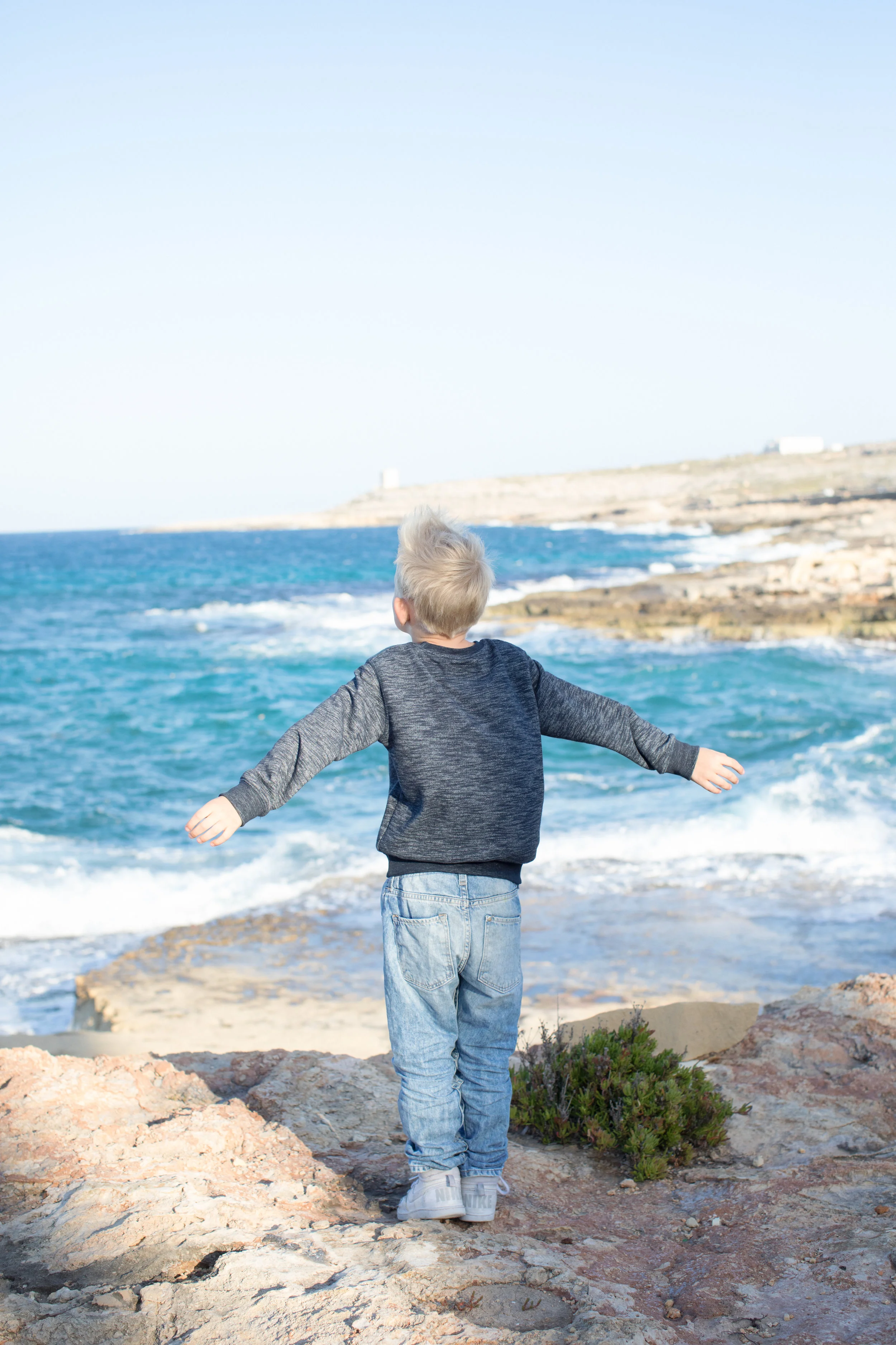 bahar-ic caghaq, mediterranean sea, children photographer malta, stormy sea, windy, whimsical happy child, cliffs, playing, childhood 