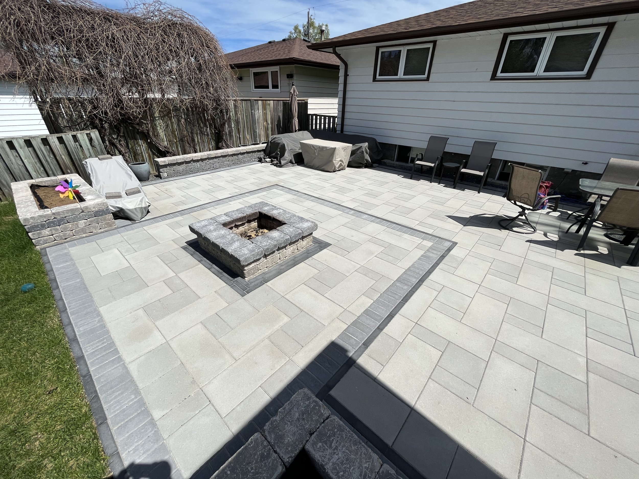  Barkman Broadway Paver patio with a Nordic Stone/westmount (Techo-Bloc) border. Center fire pit feature, as well as some Quarry Stone planter Beds. 