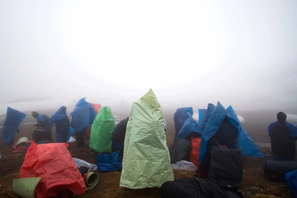 47.Students-sheilding-themselves-from-the-rain-at-the-advance-base-camp-after-descending-from-camp-1.jpg