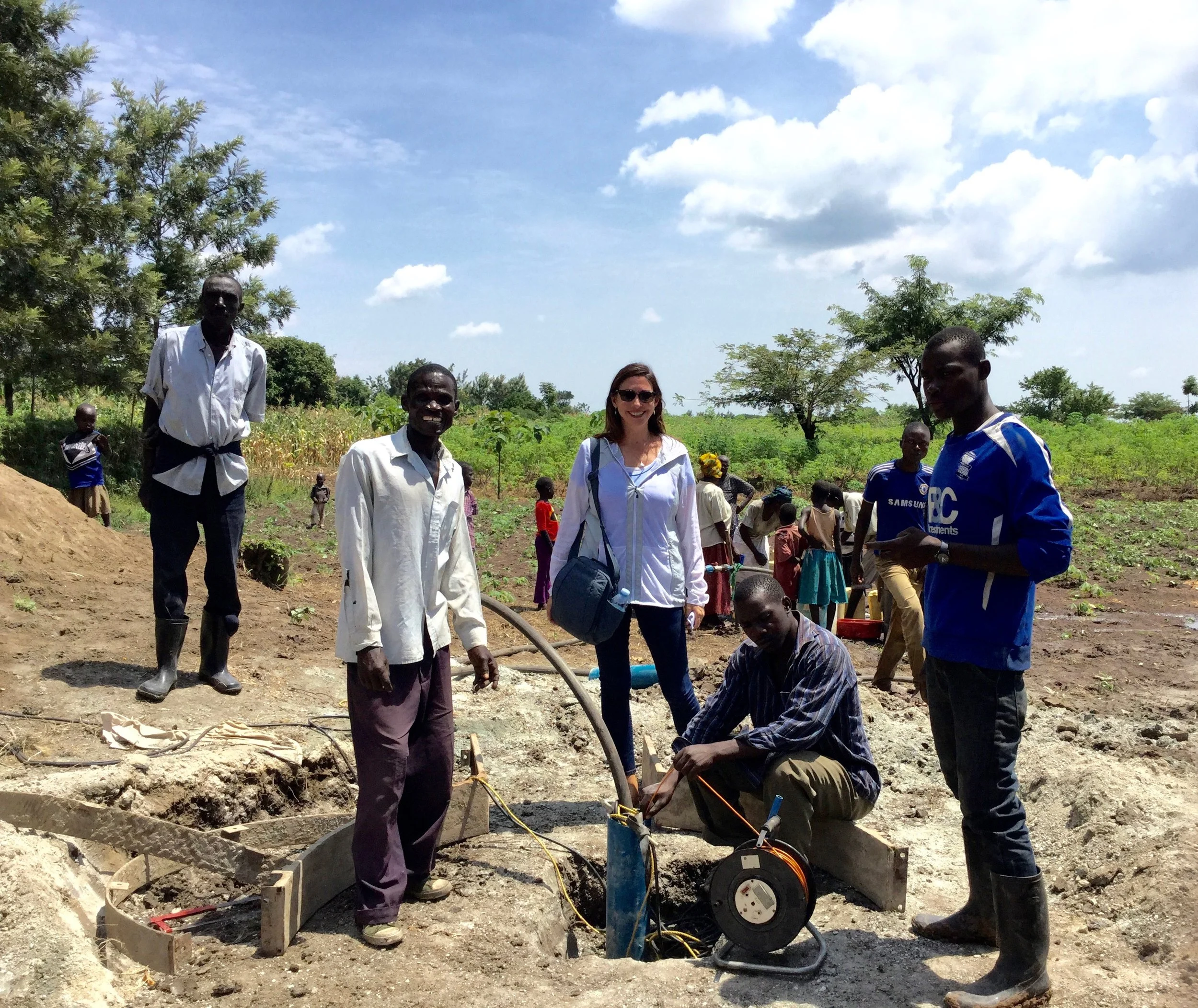 Tuktuana Director Roxanne Robbins watches as a hand pump is installed at a drill site in Busiu, Uganda. 