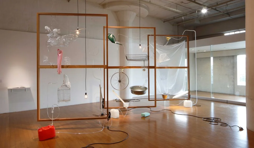 Yuko Mohri, Moré Moré (Leaky): The Falling Water Given #1-3 , 2015, wood, umbrella, hose, PET bottles, rubber glove, bucket, wheel, duster, sponge, pump, acrylic resin, etc. Installation view at Nissan Art Award 2015 Exhibition. Photo by Keizo Kioku