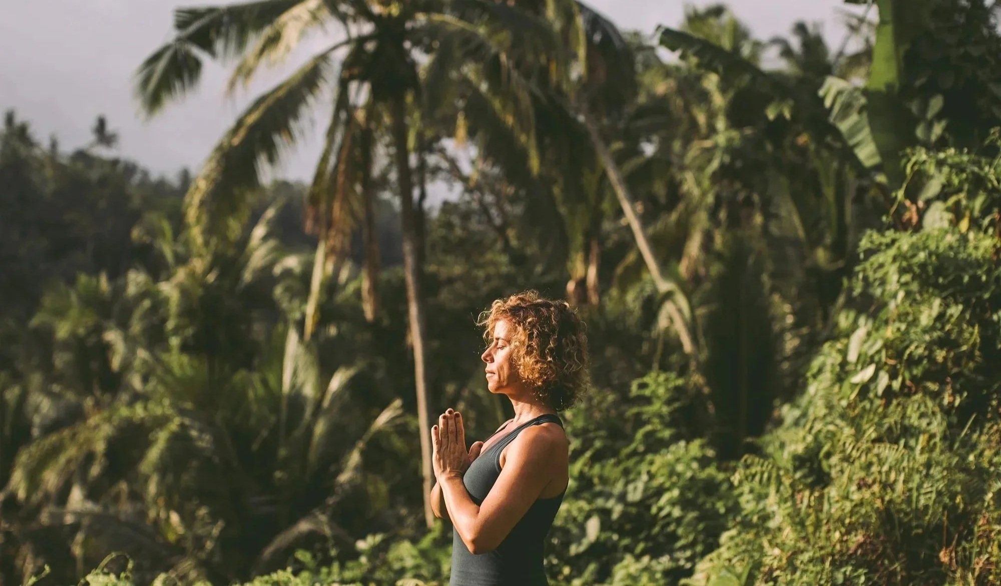Female instrcutor practicing yoga during a breathwork and sound healing retreat in nature