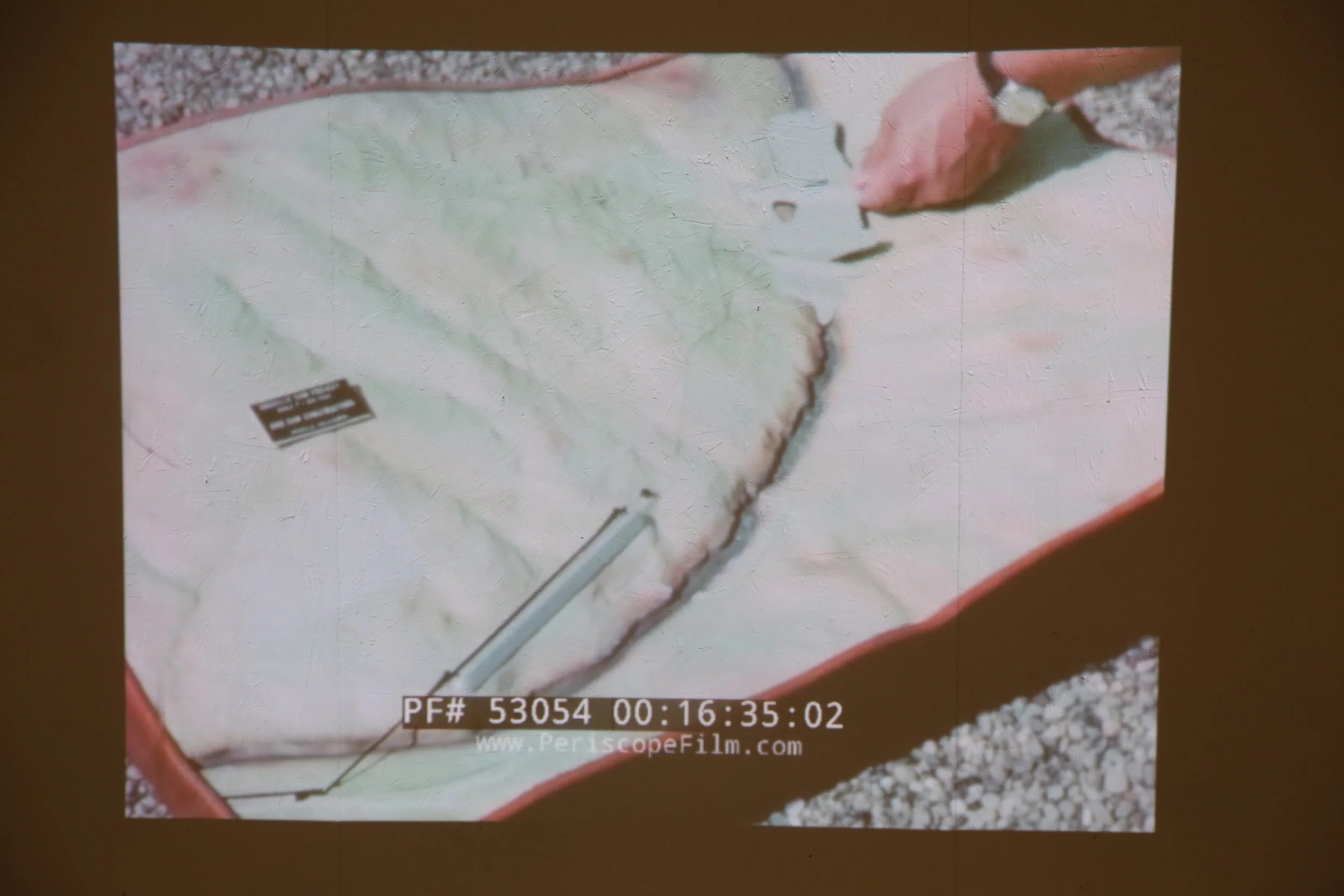     where every body is pressed together and recovering from pressing, as if that is the world,  California Institute of the Arts, 2019    Two-channel video installation, concrete, organic rock, raw clay, fired clay, water, mirror, vinyl, glass, pape