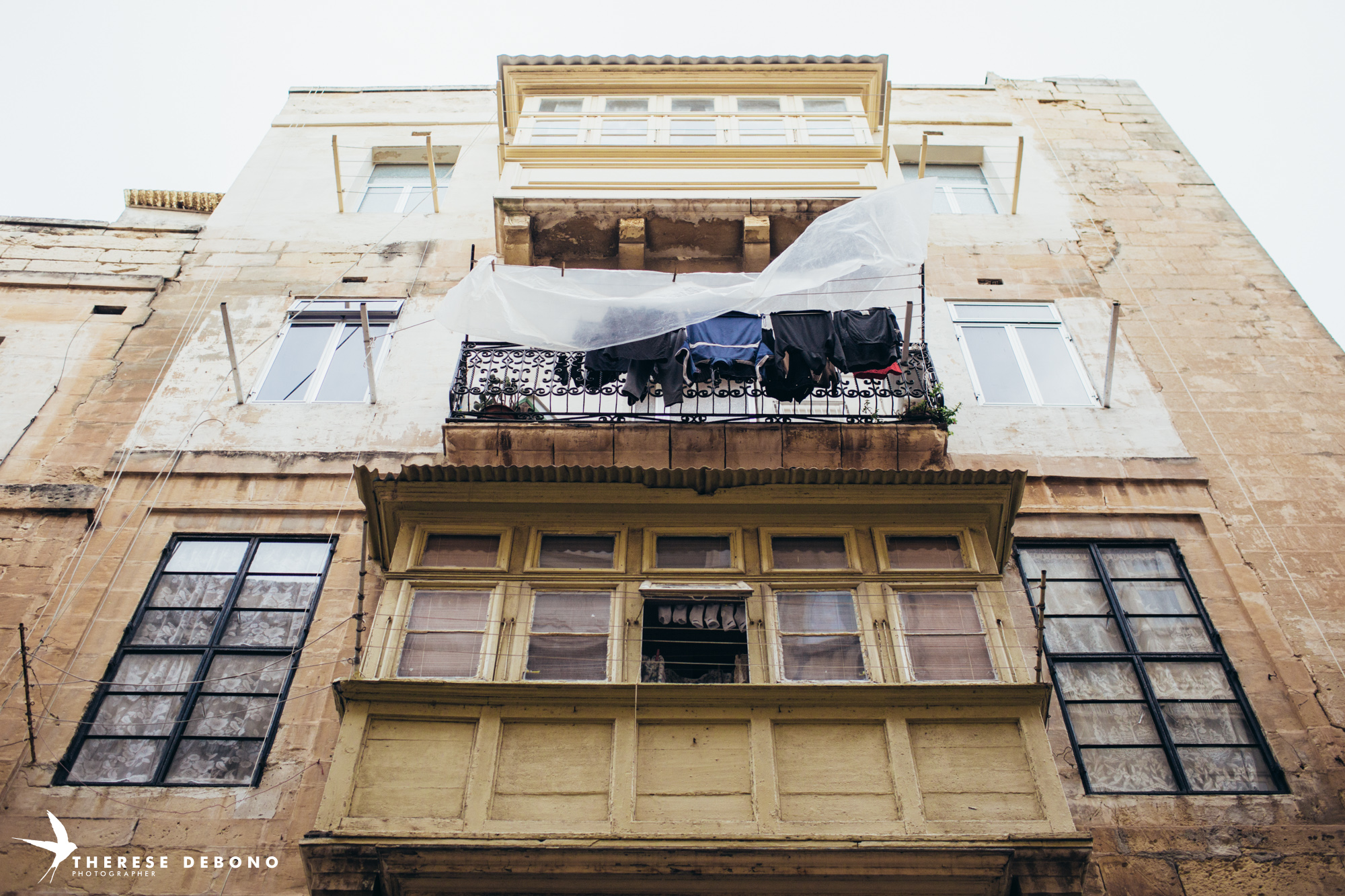 Covering laundry with sheets of plastic to protect it from the rain