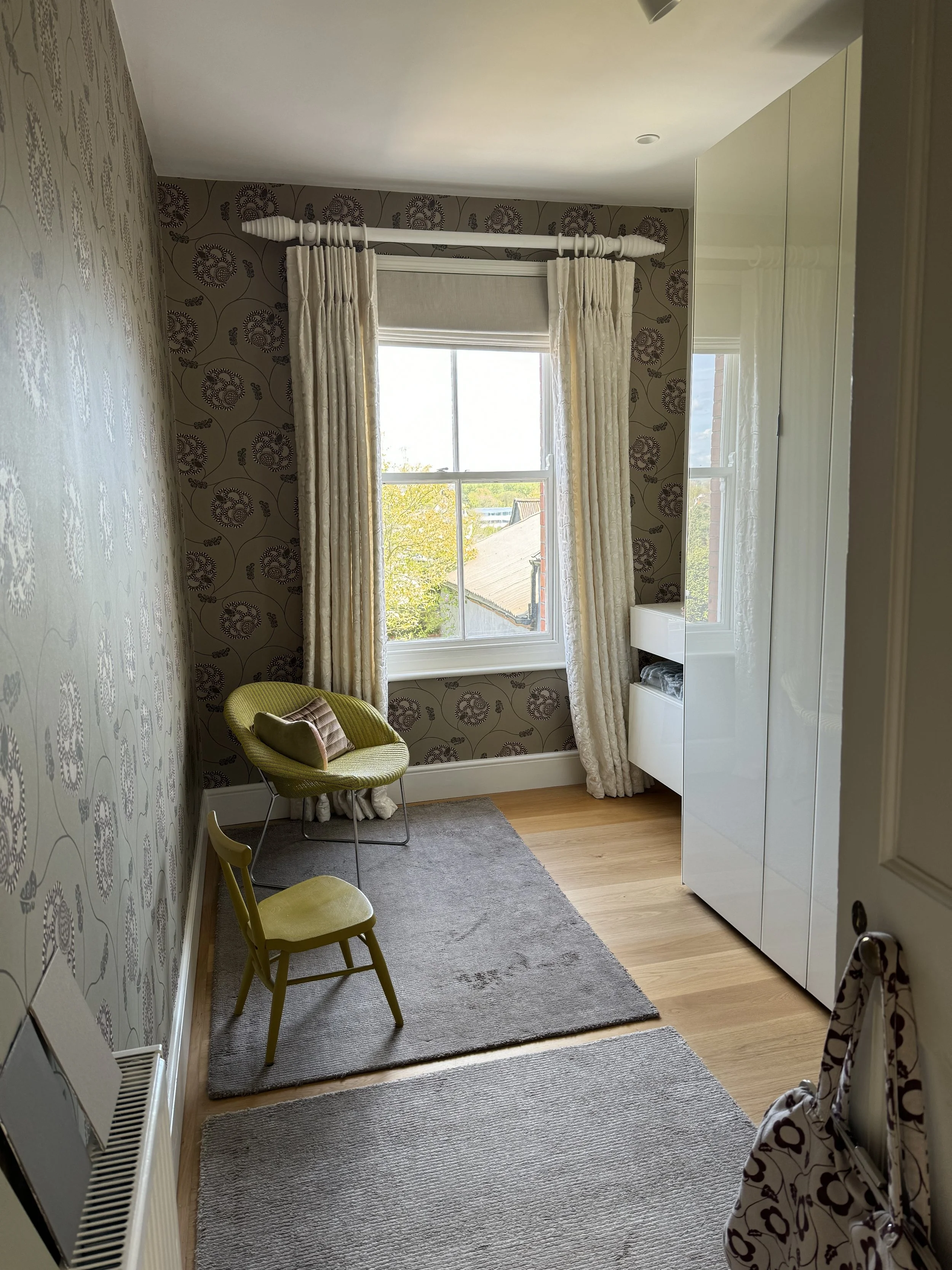 Former guest bedroom with embroidered ivory curtains, Roman blind and patterned wallpaper by Neisha Crosland.