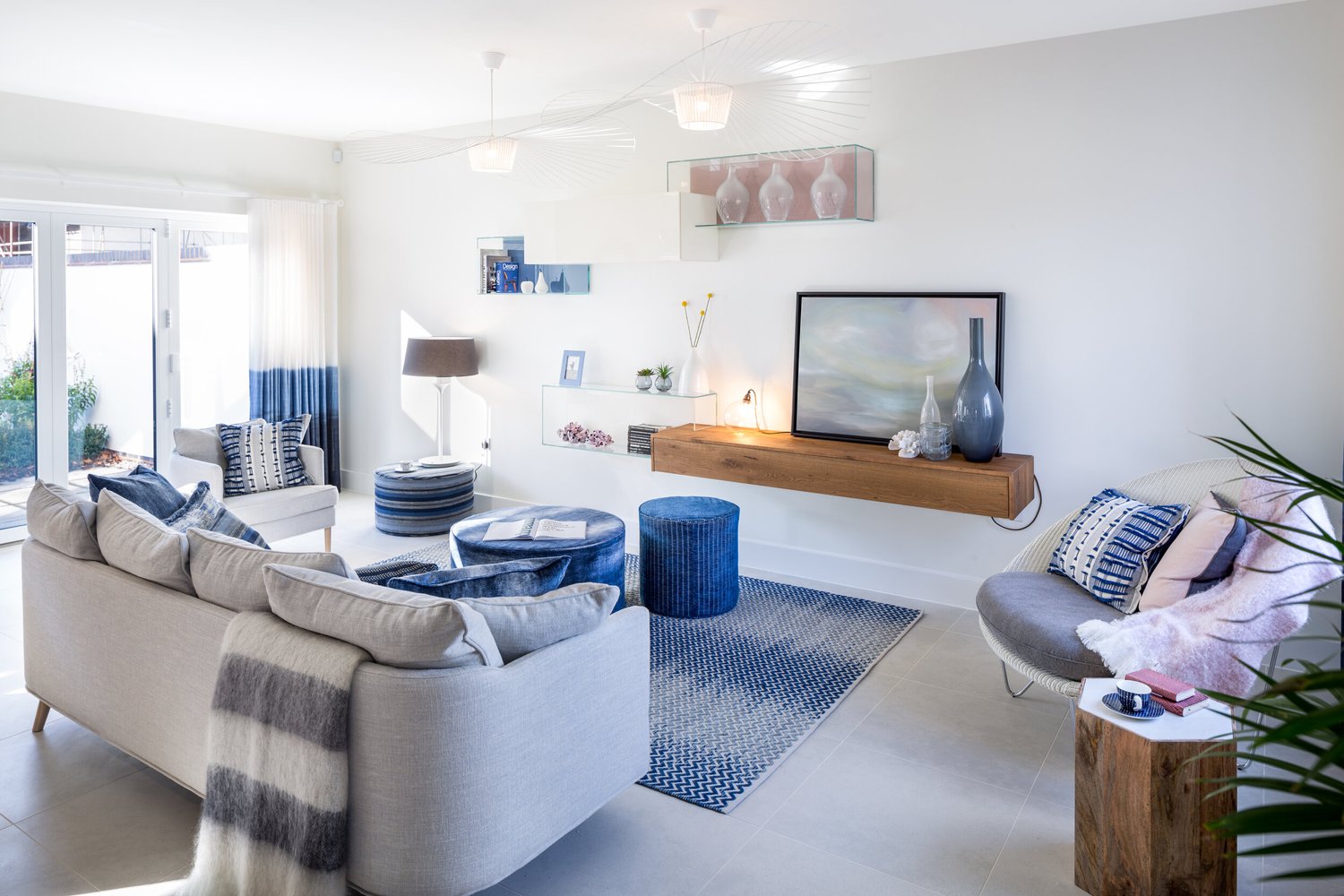 Open plan coastal living room with grey sofa and ombre blue curtains in Topsham designed by Michelle Sucksmith