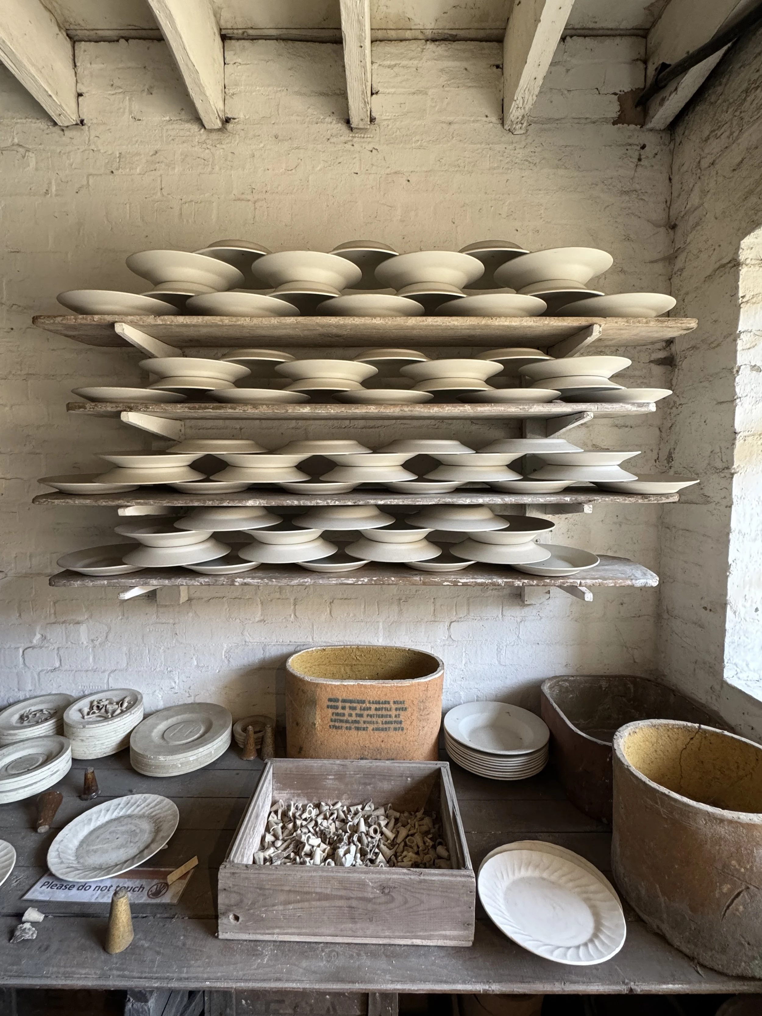 Unfired plates drying on wooden racks in a potter's workshop, Gladstone Pottery Museum