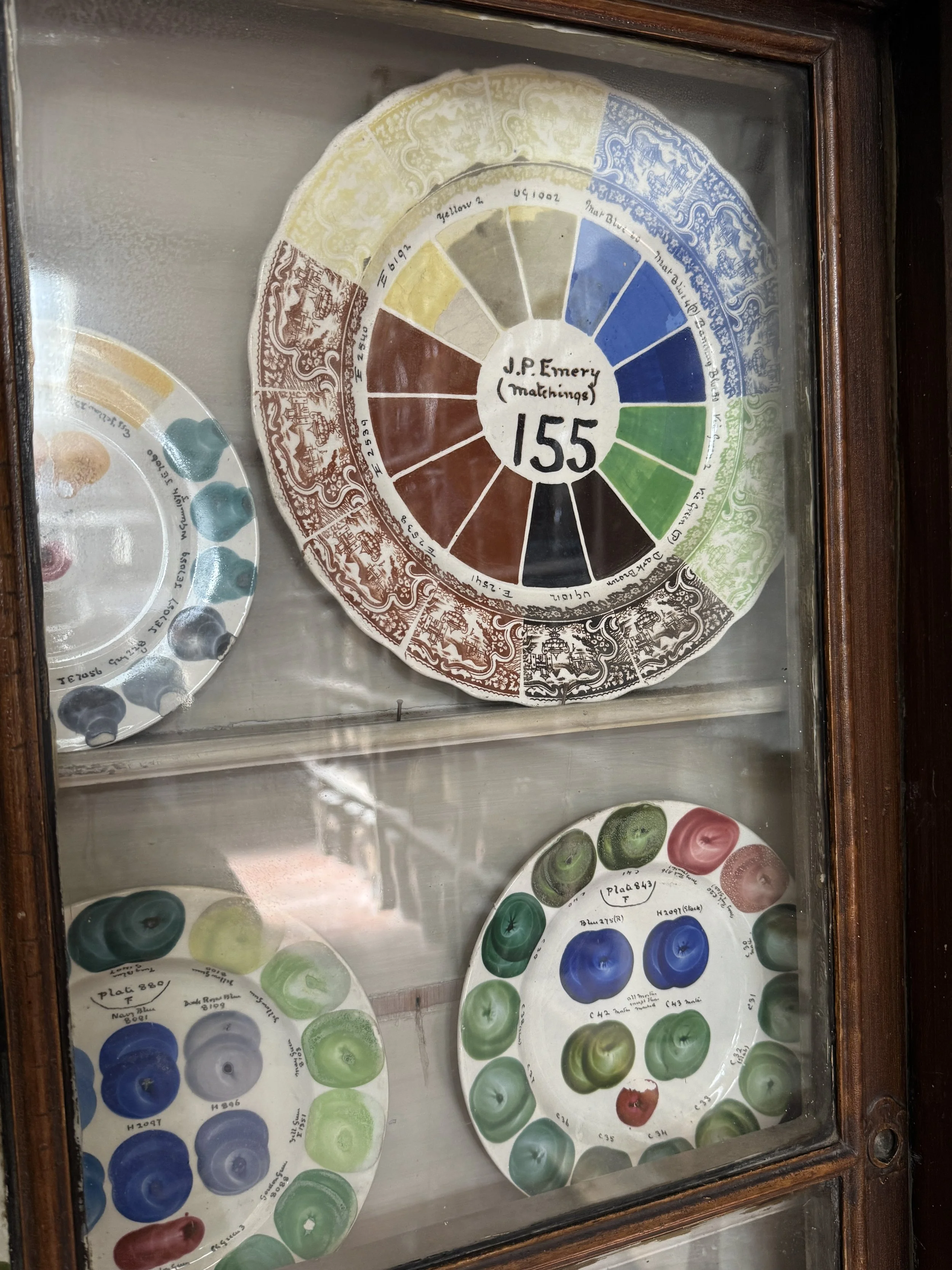 Glaze colour wheel test plates in a glass fronted cabinet, Gladstone Pottery Museum