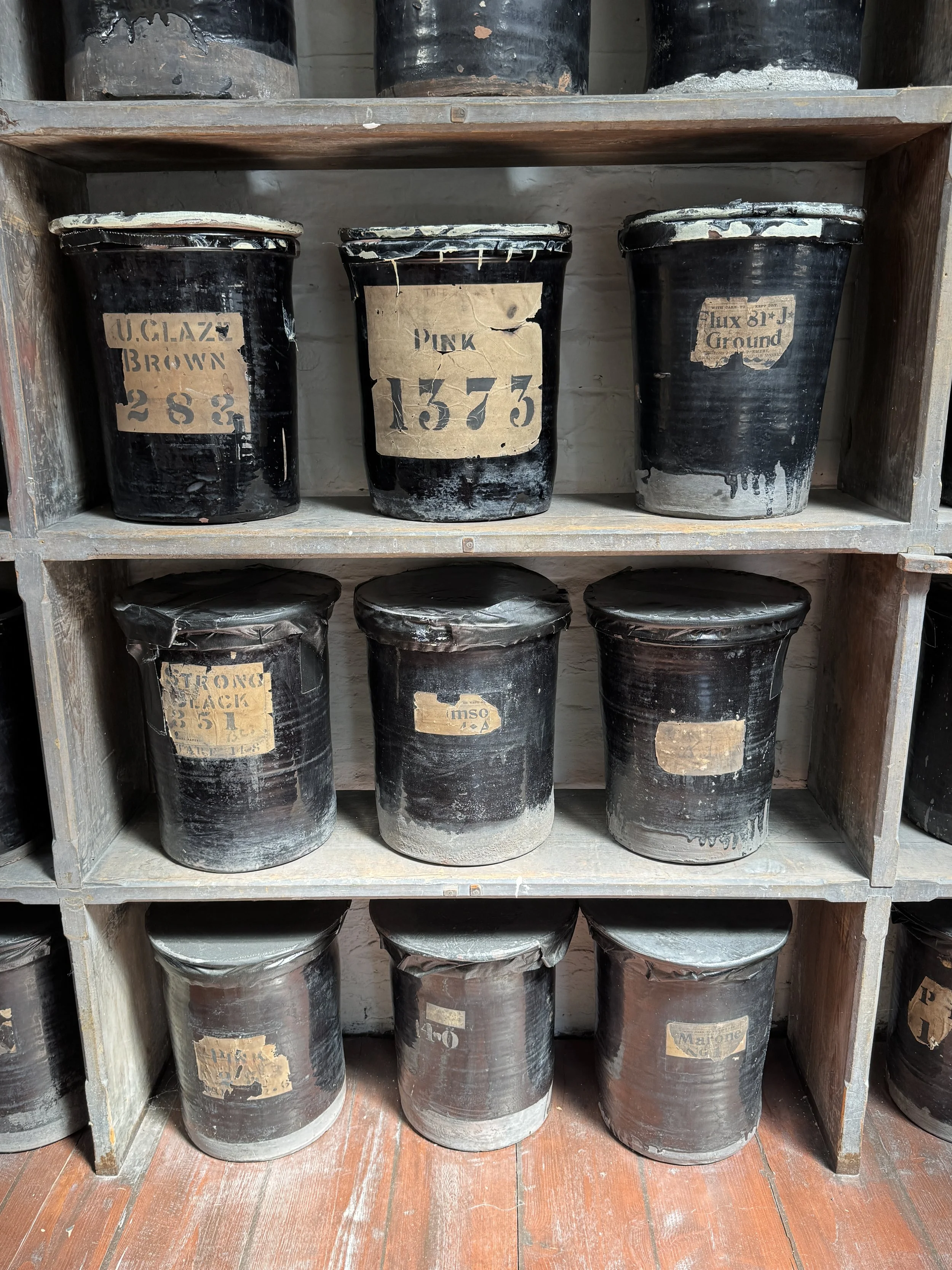 Old labelled glaze and colour jars on wooden shelves, Gladstone Pottery Museum