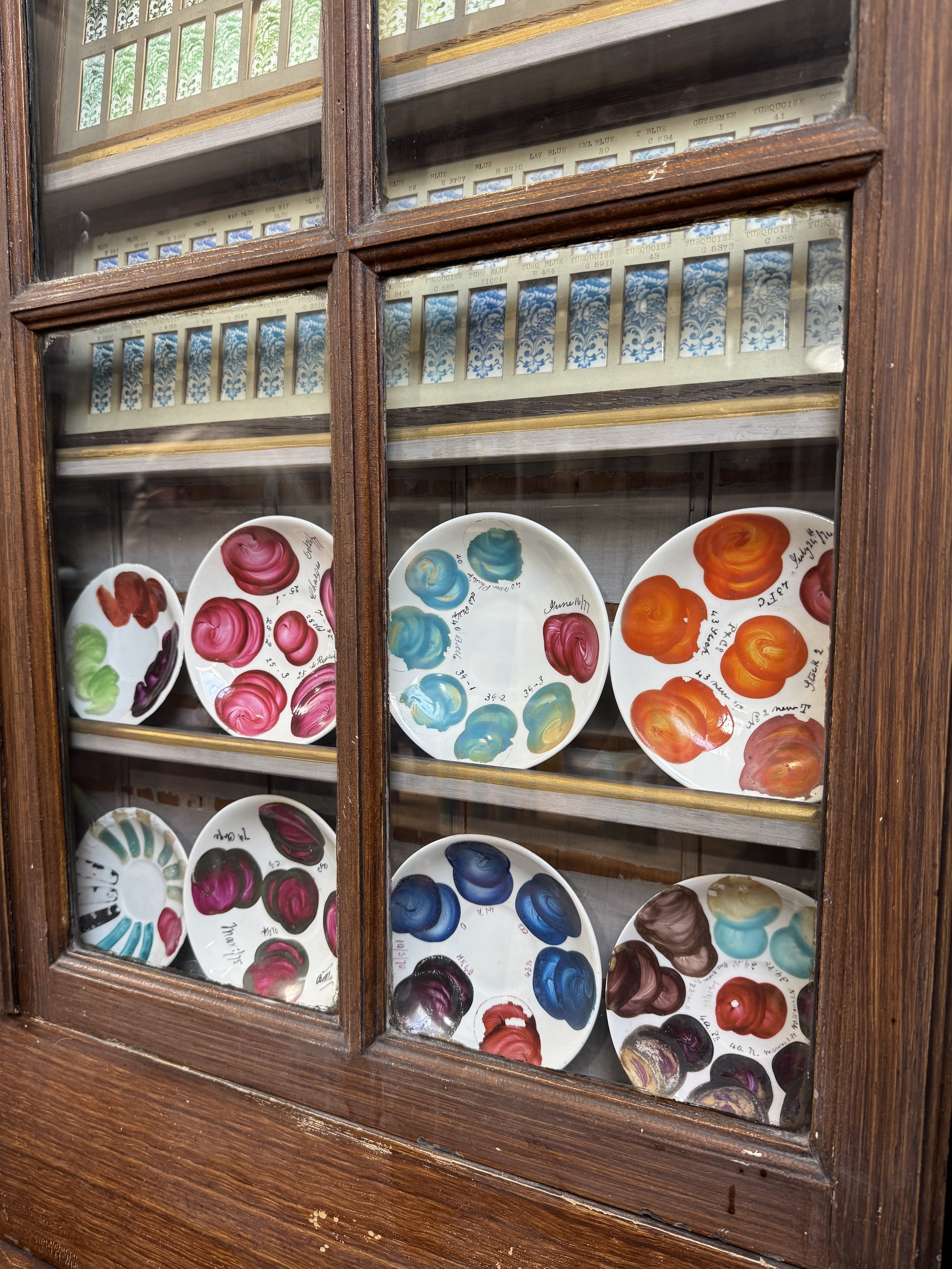 Painted colour test plates in a glazed cabinet, Gladstone Pottery Museum