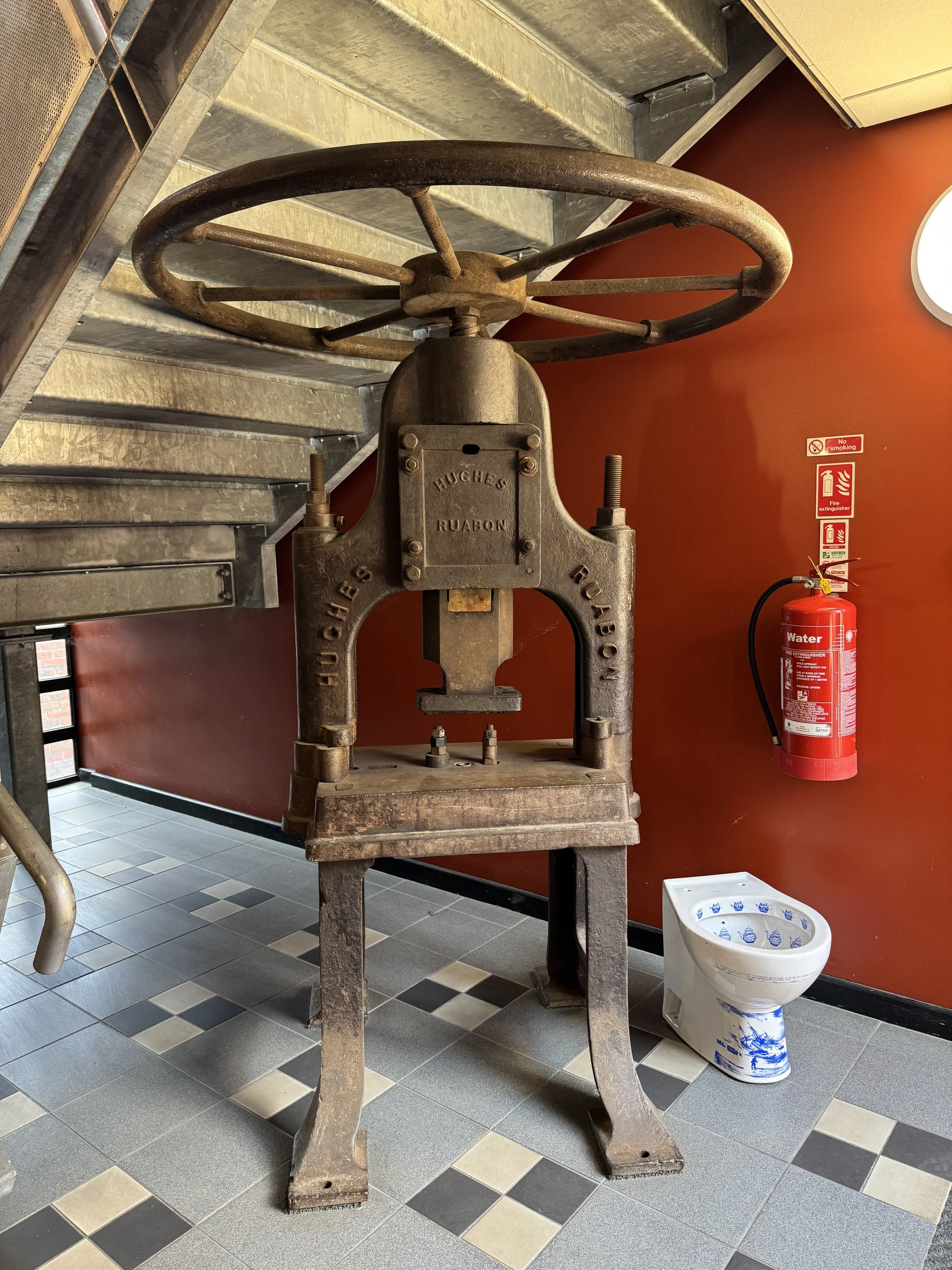 Cast iron press beside a decorated toilet, Gladstone Pottery Museum