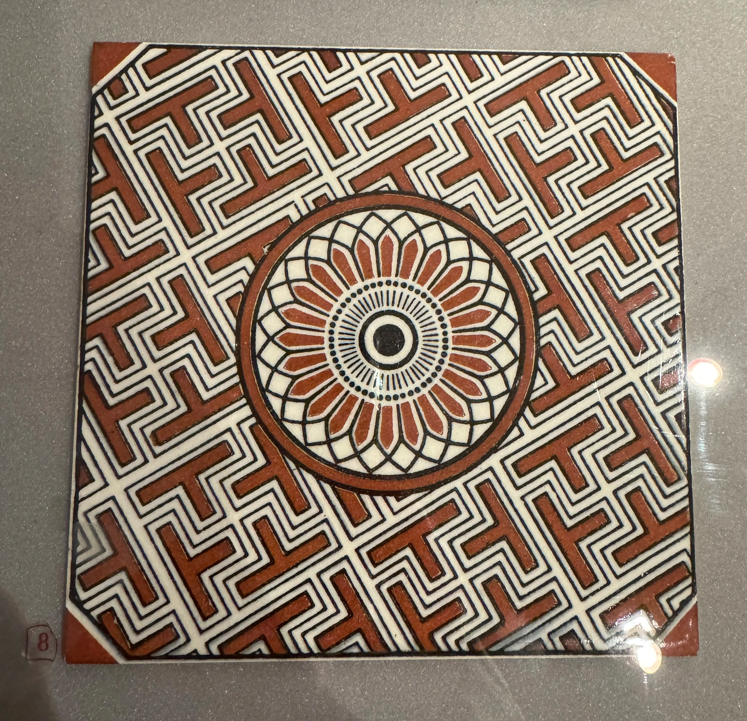 Red and white geometric tile with a sunburst centre, Gladstone Pottery Museum