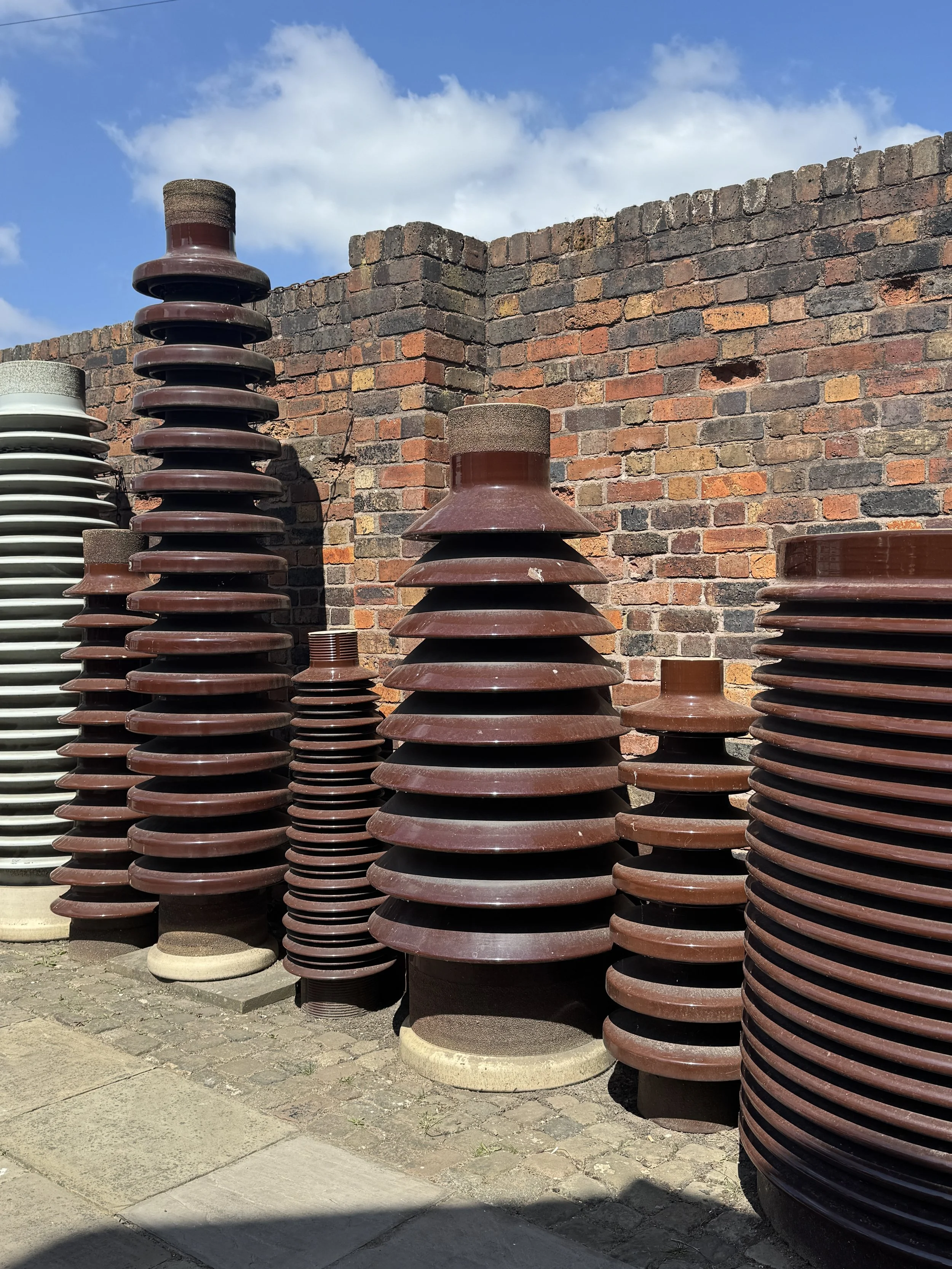 Stacks of brown glazed ceramic insulators in the yard, Gladstone Pottery Museum