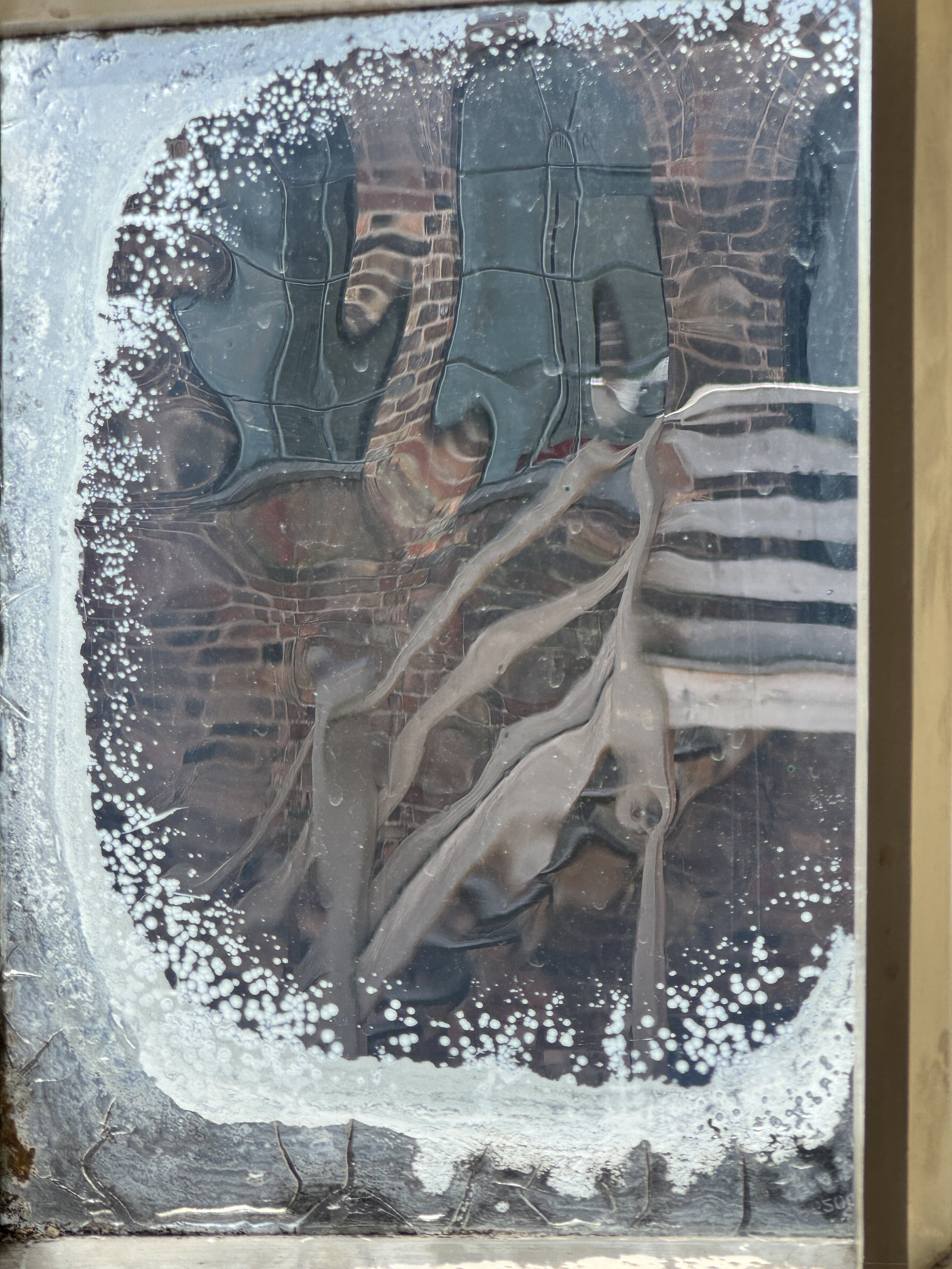 Historic window glass rippling the view of the courtyard, Gladstone Pottery Museum