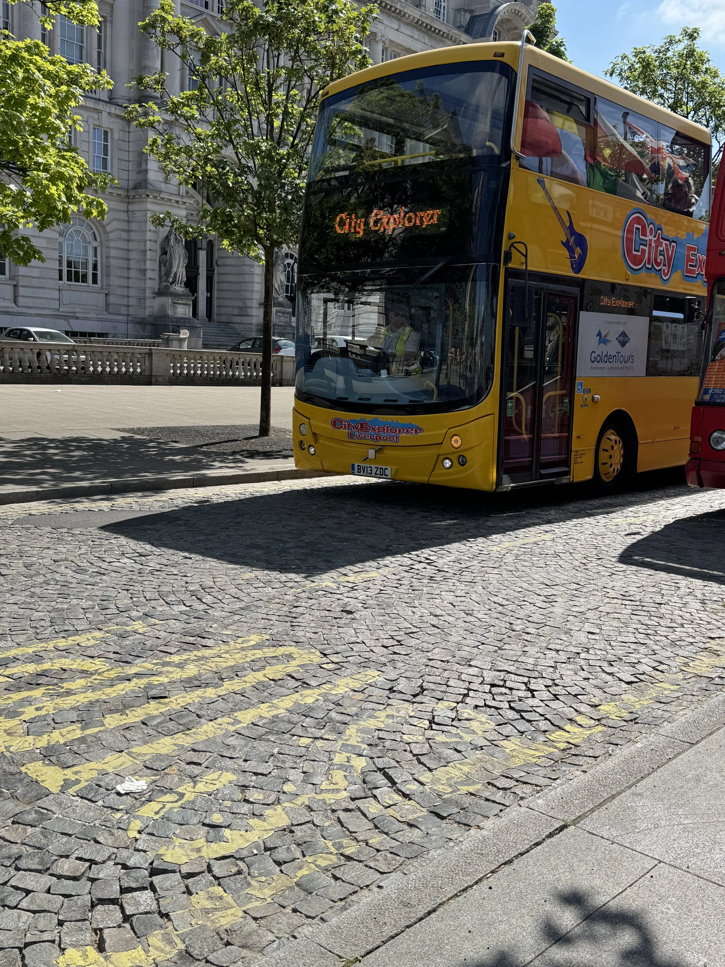 Yellow open-top tour bus on a cobbled street, Liverpool