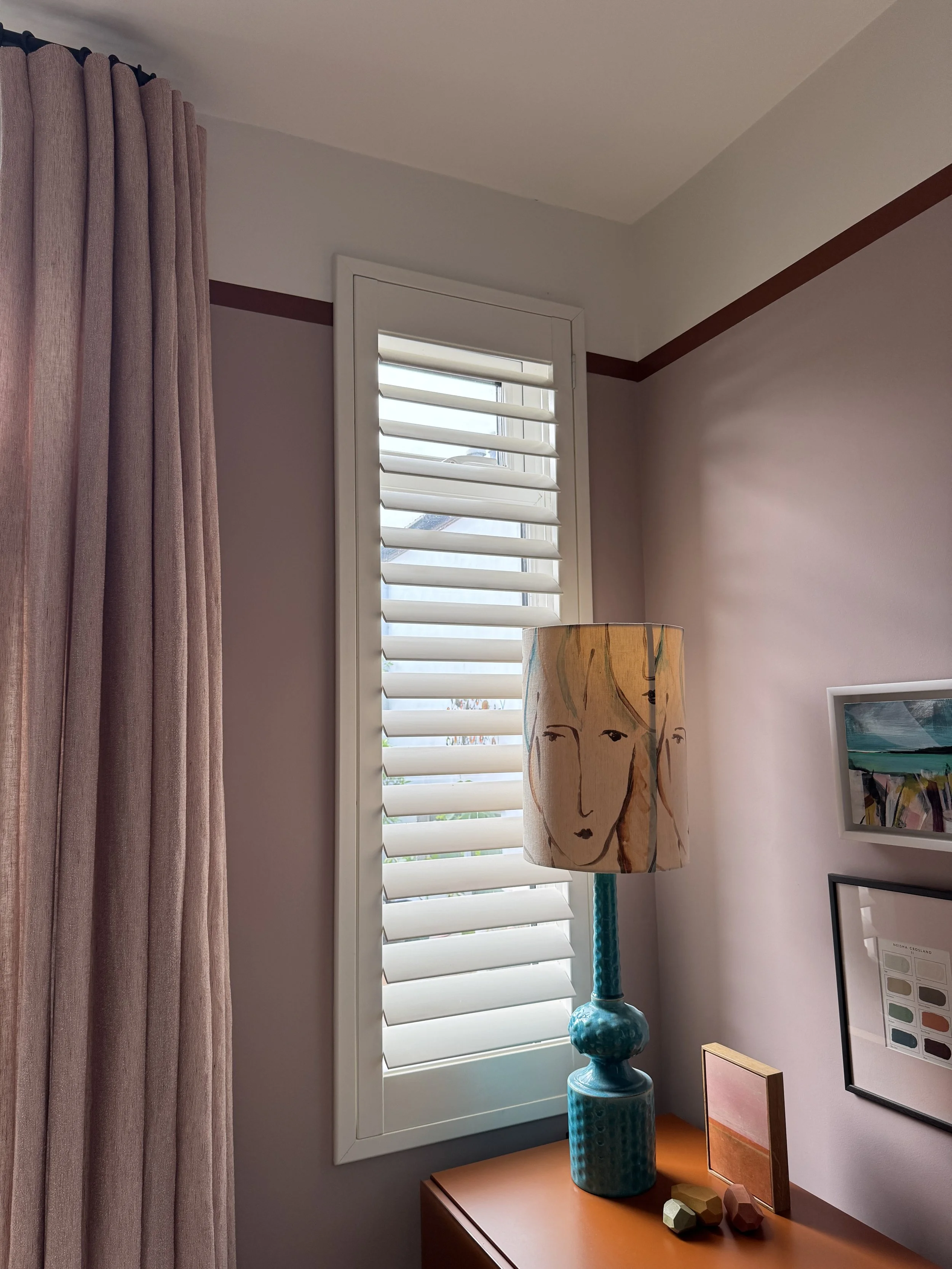  Floor-to-ceiling bespoke curtains in Kvadrat Bouclin fabric paired with plantation shutters, showing how subtle colour matching creates a calm and cohesive window treatment scheme. 