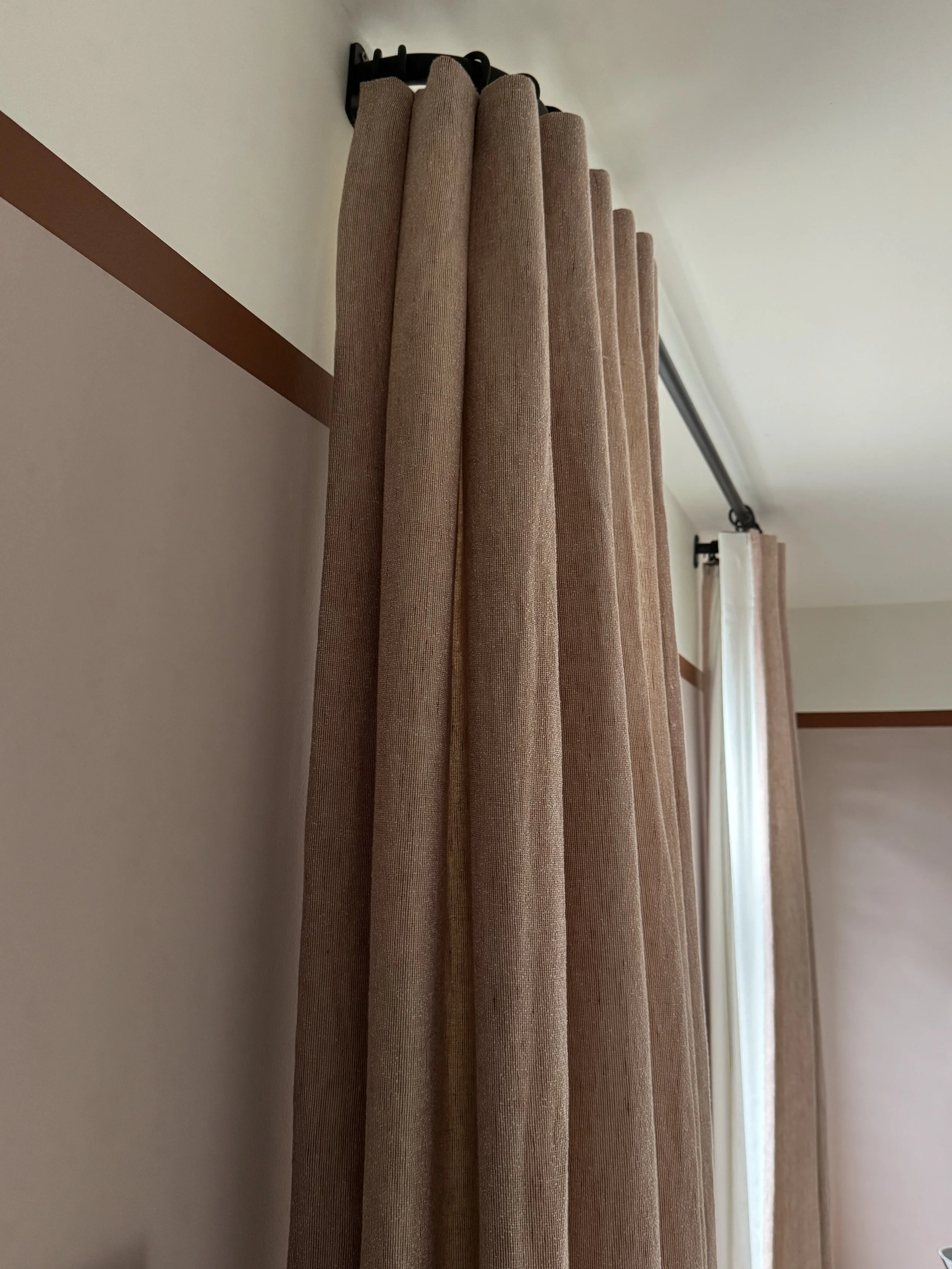  Close-up of inverted pleat curtain heading in textured Kvadrat Bouclin fabric, demonstrating the craftsmanship and tailored finish of bespoke curtains. 